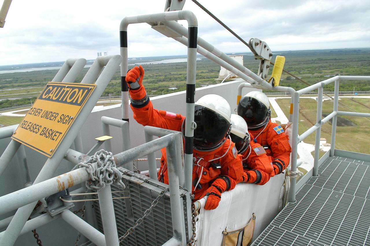 KENNEDY SPACE CENTER, FLA. --   From the 195-foot level of the fixed service structure on Launch Pad 39B, STS-116 crew members sit in a slidewire basket, part of the emergency egress system.  In the front is Mission Specialist Sunita Williams; behind her are Mission Specialists Joan Higginbotham and Christer Fuglesang.  They and other crew members are practicing the emergency egress procedure to get off the pad, part of the prelaunch preparations known as terminal countdown demonstration test. The TCDT includes a simulated launch countdown and payload familiarization. The STS-116 mission is No. 20 to the International Space Station and construction flight 12A.1.  The mission payload is the SPACEHAB module, the P5 integrated truss structure and other key components. Launch is scheduled for no earlier than Dec. 7. Photo credit: NASA/Kim Shiflett
