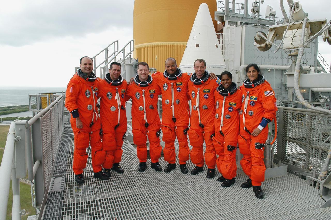 KENNEDY SPACE CENTER, FLA. --  On the 195-foot level of the fixed service structure on Launch Pad 39B, STS-116 crew members gather for a photo in front of the white solid rocket boosters and external tank of Space Shuttle Discovery. They have just completed a simulated launch countdown and emergency egress from the orbiter.  From left are Commander Mark Polansky, Pilot William Oefelein and Mission Specialists Nicholas Patrick, Robert Curbeam, Christer Fuglesang, Joan Higginbotham and Sunita Williams.  Fuglesang represents the European Space Agency.  Williams is traveling to the International Space Station on Discovery and will remain behind as a flight engineer with the Expedition 14 crew.  The STS-116 mission is No. 20 to the International Space Station and construction flight 12A.1.  The mission payload is the SPACEHAB module, the P5 integrated truss structure and other key components. Launch is scheduled for no earlier than Dec. 7. Photo credit: NASA/Kim Shiflett