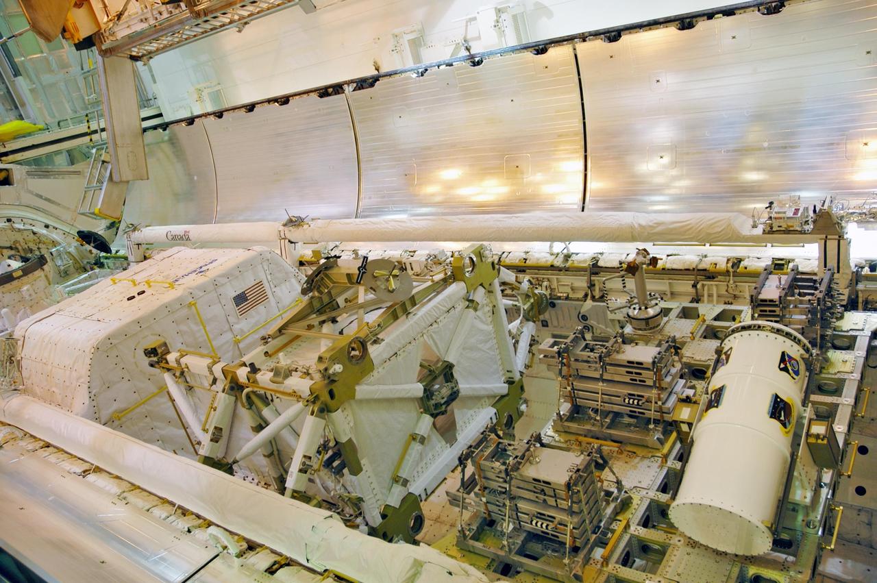 KENNEDY SPACE CENTER, FLA. --  With the payload successfully installed inside, the payload bay doors on Space Shuttle Discovery are closing.  Seen here are the SPACEHAB module at left, the P5 truss in the center, service module debris panels and the Space Test Program experiment canister on the integrated cargo carrier at right. The shuttle is on Launch Pad 39B, ready for launch on mission STS-116 scheduled no earlier than Dec. 7.  Photo credit: NASA/Dimitri Gerondidakis