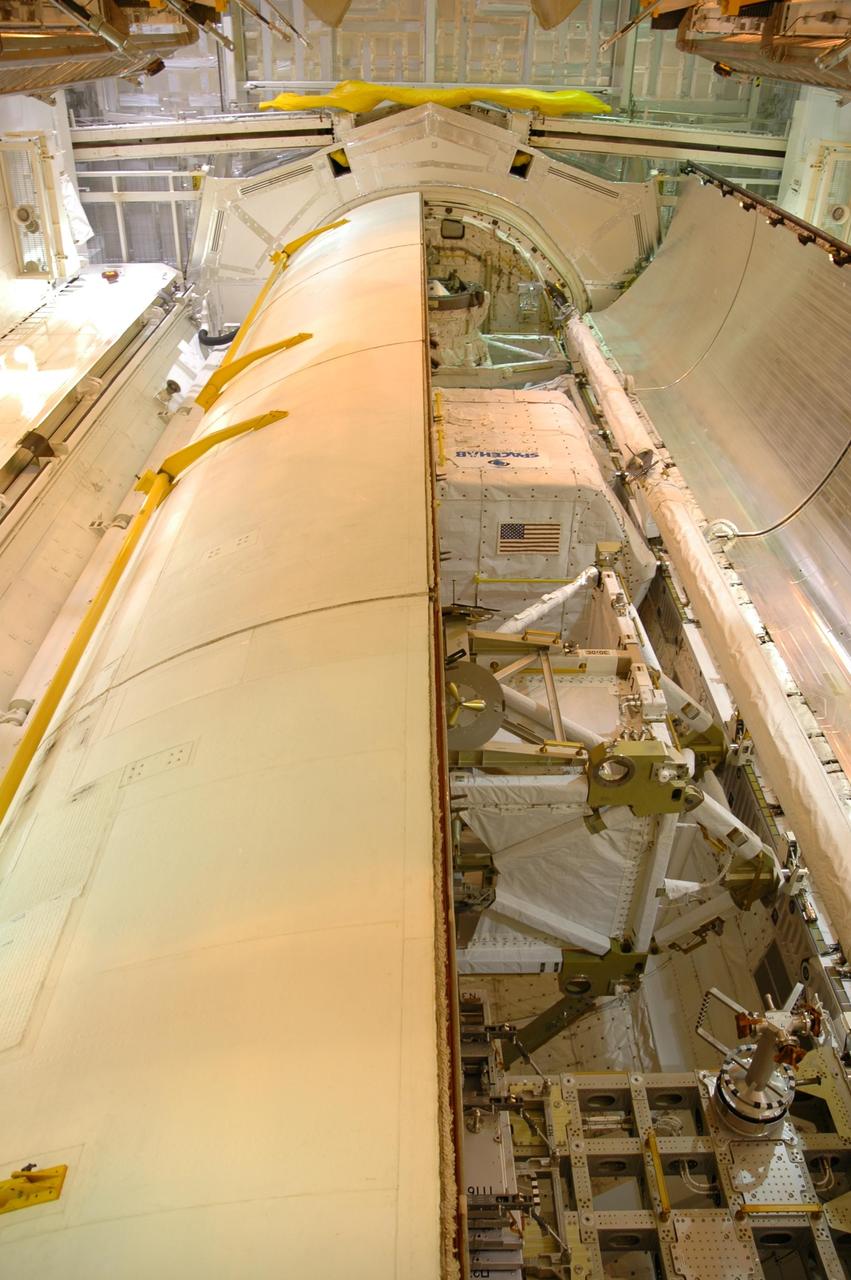 KENNEDY SPACE CENTER, FLA. --  One of Space Shuttle Discovery's payload bay doors is nearly closed.  Still visible are two major payload components,  the SPACEHAB module on top and the P5 truss below. Launch of Space Shuttle Discovery on mission STS-116 is scheduled no earlier than Dec. 7.  Photo credit: NASA/Dimitri Gerondidakis