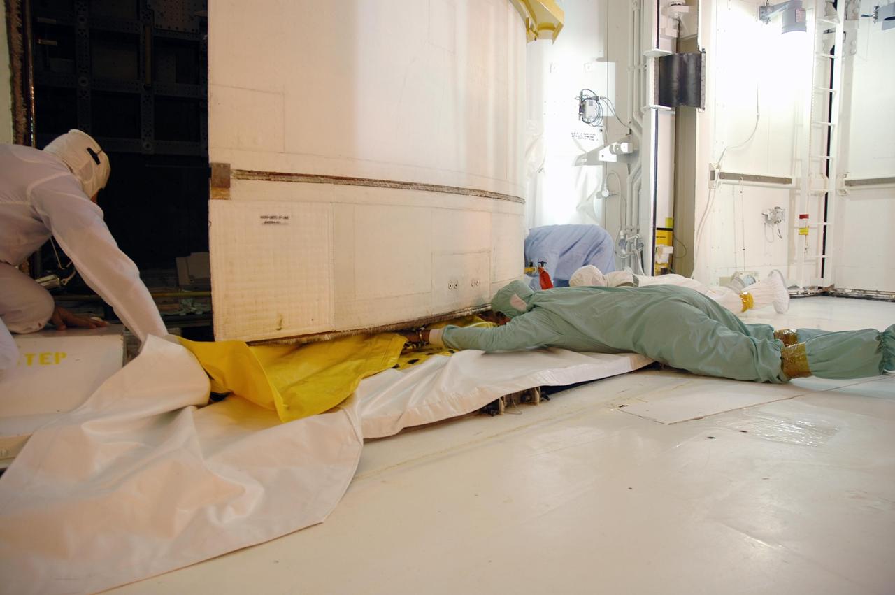 KENNEDY SPACE CENTER, FLA. --  On Launch Pad 39B, technicians check the clearance under the payload door on Space Shuttle Discovery as the door closes. The payload includes the SPACEHAB module, the P5 integrated truss structure and other key components. Launch of Space Shuttle Discovery on mission STS-116 is scheduled no earlier than Dec. 7.  Photo credit: NASA/Dimitri Gerondidakis