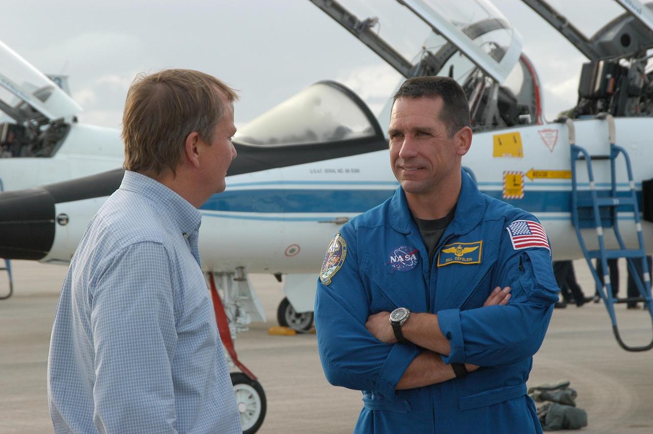 KENNEDY SPACE CENTER, FLA. -- At the Shuttle Landing Facility, Launch Director Mike Leinbach (left) welcomes STS-116 Pilot William Oefelein upon his arrival at KSC aboard a T-38 jet aircraft for the launch of Space Shuttle Discovery on Dec. 7. On the mission, the STS-116 crew will deliver truss segment, P5, to the International Space Station and begin the intricate process of reconfiguring and redistributing the power generated by two pairs of U.S. solar arrays. The P5 will be mated to the P4 truss that was delivered and attached during the STS-115 mission in September. Photo credit: NASA/Kim Shiflett
