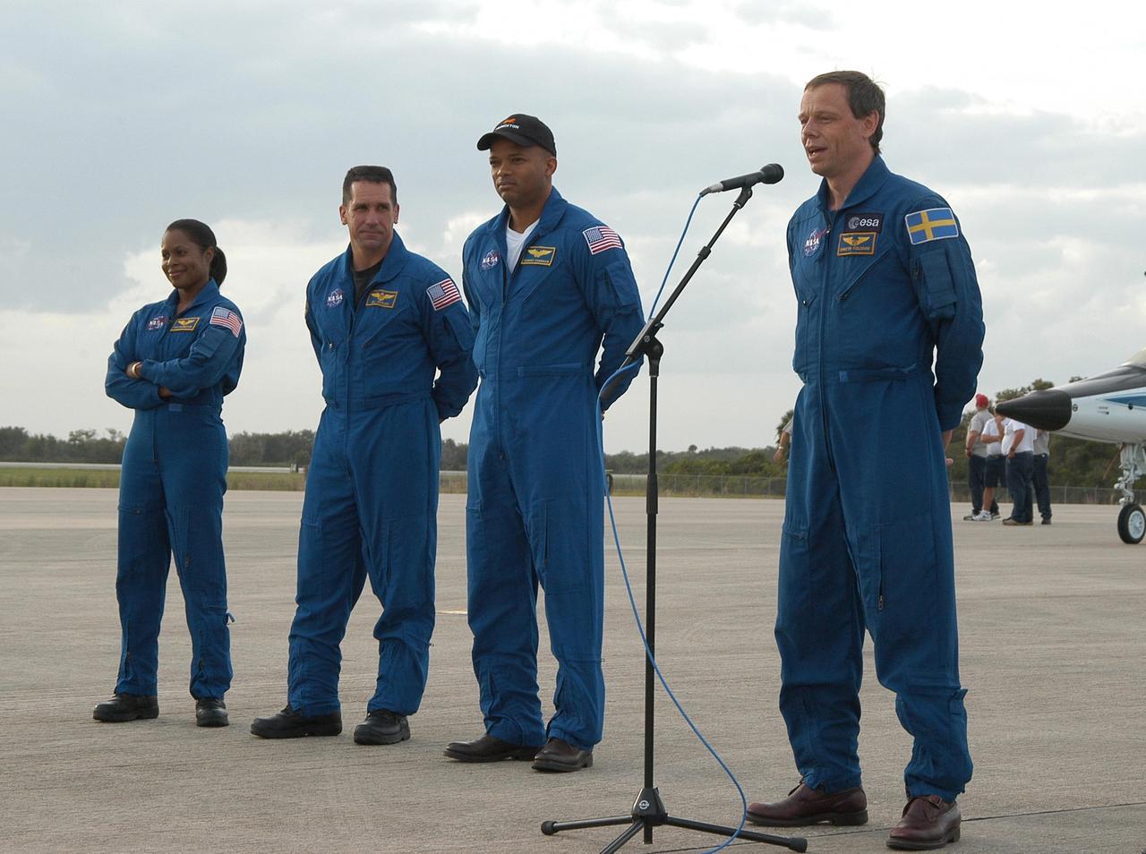 KENNEDY SPACE CENTER, FLA. --  At the Shuttle Landing Facility, members of the STS-116 crew address media representatives on hand for their arrival at KSC aboard T-38 jet aircraft for the launch of Space Shuttle Discovery on Dec. 7. From left are Mission Specialist Joan Higginbotham; Pilot William Oefelein; Mission Specialist Robert Curbeam; and Mission Specialist Christer Fuglesang, a Swedish astronaut representing the European Space Agency (at the microphone).  On the mission, the STS-116 crew will deliver truss segment, P5, to the International Space Station and begin the intricate process of reconfiguring and redistributing the power generated by two pairs of U.S. solar arrays.  The P5 will be mated to the P4 truss that was delivered and attached during the STS-115 mission in September.  Photo credit: NASA/Kim Shiflett