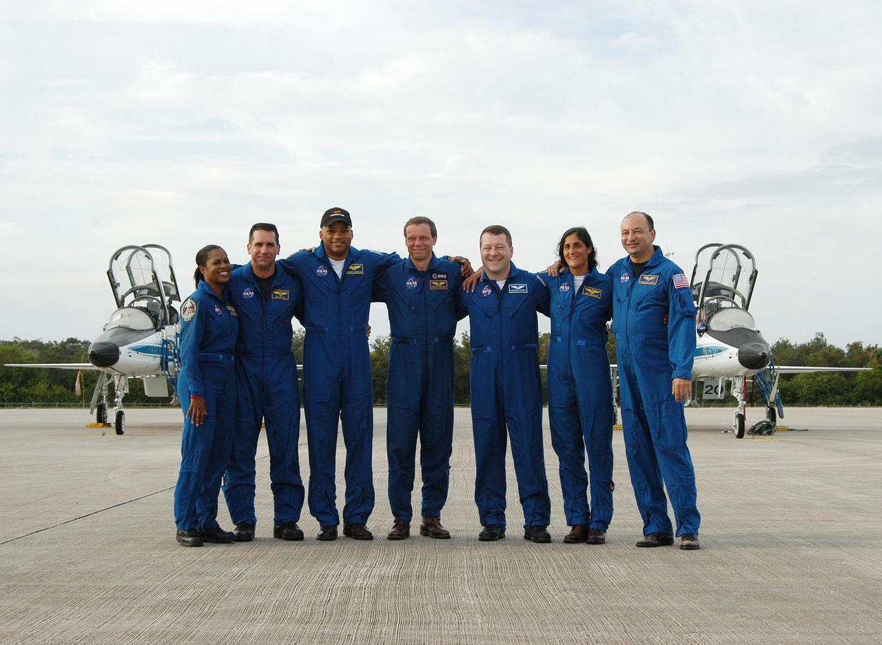 KENNEDY SPACE CENTER, FLA. -- At the Shuttle Landing Facility, the STS-116 crew poses for media representatives on hand for their arrival at KSC aboard T-38 jet aircraft for the launch of Space Shuttle Discovery on Dec. 7. From left are Mission Specialist Joan Higginbotham; Pilot William Oefelein; Mission Specialists Robert Curbeam, Christer Fuglesang representing the European Space Agency, Nicholas Patrick, and Sunita Williams joining Expedition 14 in progress on the International Space Station; and Commander Mark Polansky. On the mission, the STS-116 crew will deliver truss segment, P5, to the International Space Station and begin the intricate process of reconfiguring and redistributing the power generated by two pairs of U.S. solar arrays. The P5 will be mated to the P4 truss that was delivered and attached during the STS-115 mission in September. Photo credit: NASA/Kim Shiflett