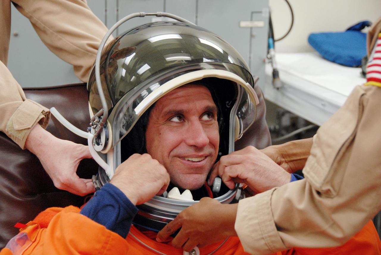 KENNEDY SPACE CENTER, FLA. --   Following orbiter landing practice in the shuttle training aircraft (STA), STS-116 Pilot William Oefelein adjusts his helmet during suit fit-check.  Launch of Space Shuttle Discovery on mission STS-116 is scheduled for 9:35 p.m. Dec. 7. On the mission, the STS-116 crew will deliver truss segment, P5, to the International Space Station and begin the intricate process of reconfiguring and redistributing the power generated by two pairs of U.S. solar arrays. The P5 will be mated to the P4 truss that was delivered and attached during the STS-115 mission in September. Photo credit: NASA/Kim Shiflett