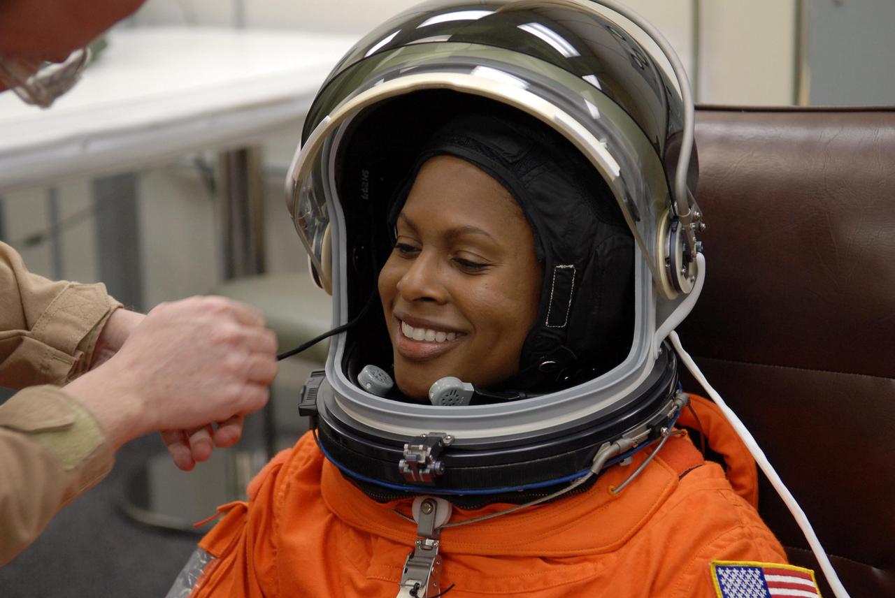KENNEDY SPACE CENTER, FLA. --  The crew members of mission STS-116 are suiting up for launch at 9:35 p.m. EST from Launch Pad 39B aboard Space Shuttle Discovery.  Pictured here, Mission Specialist Joan Higginbotham is helped with her helmet.  Higginbotham will be making her first shuttle flight. This is Discovery's 33rd mission and the first night launch since 2003.   The 20th shuttle mission to the International Space Station, STS-116 carries another truss segment, P5. It will serve as a spacer, mated to the P4 truss that was attached in September.  After installing the P5, the crew will reconfigure and redistribute the power generated by two pairs of U.S. solar arrays. Landing is expected Dec. 19 at KSC.   Photo credit: NASA/Kim Shiflett