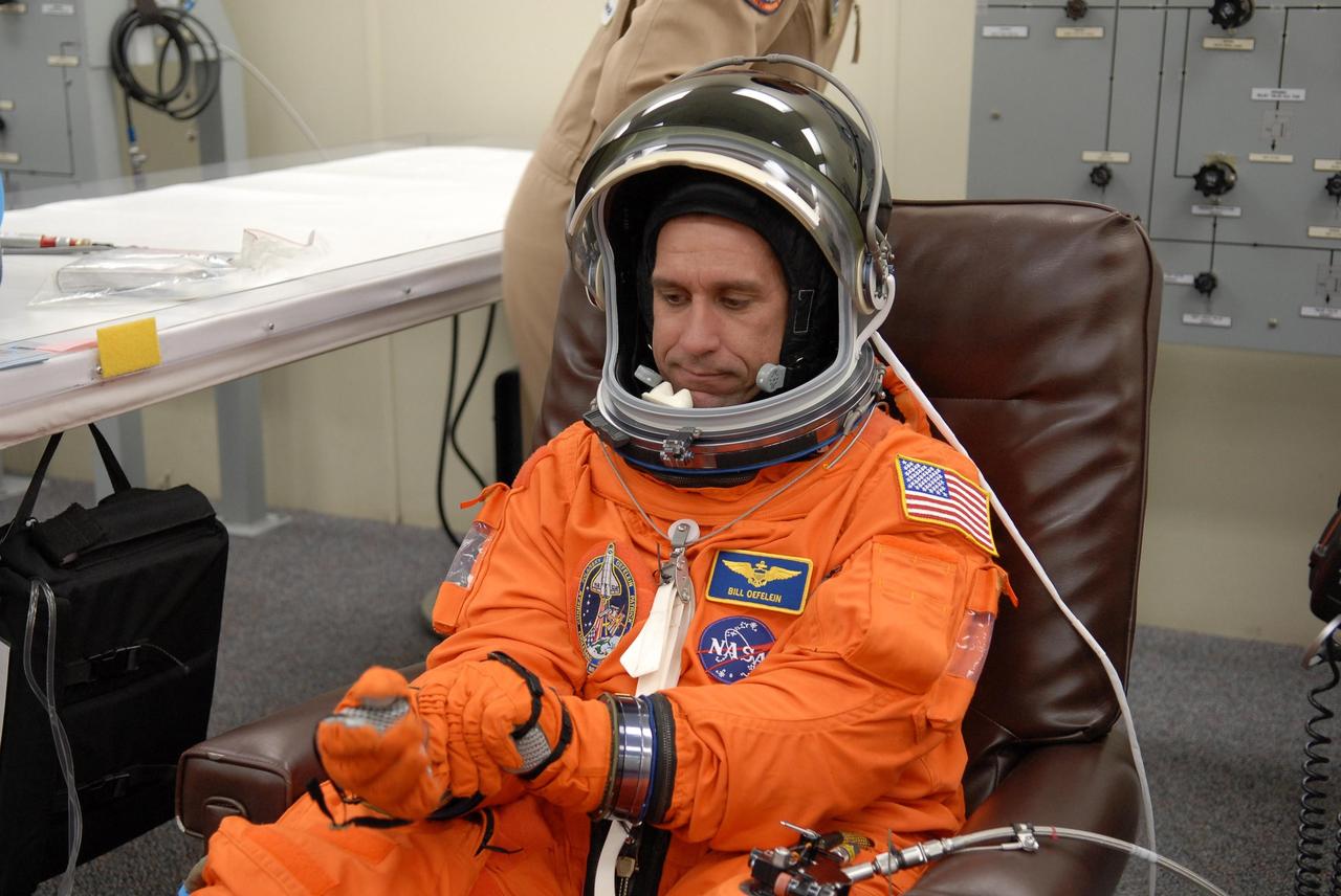 KENNEDY SPACE CENTER, FLA. -- The crew members of mission STS-116 are suiting up for launch at 9:35 p.m. EST from Launch Pad 39B aboard Space Shuttle Discovery. Pictured here is Pilot William Oefelein, adjusting his gloves. Oefelein will be making his first shuttle flight. This is Discovery's 33rd mission and the first night launch since 2003. The 20th shuttle mission to the International Space Station, STS-116 carries another truss segment, P5. It will serve as a spacer, mated to the P4 truss that was attached in September. After installing the P5, the crew will reconfigure and redistribute the power generated by two pairs of U.S. solar arrays. Landing is expected Dec. 19 at KSC. Photo credit: NASA/Kim Shiflett