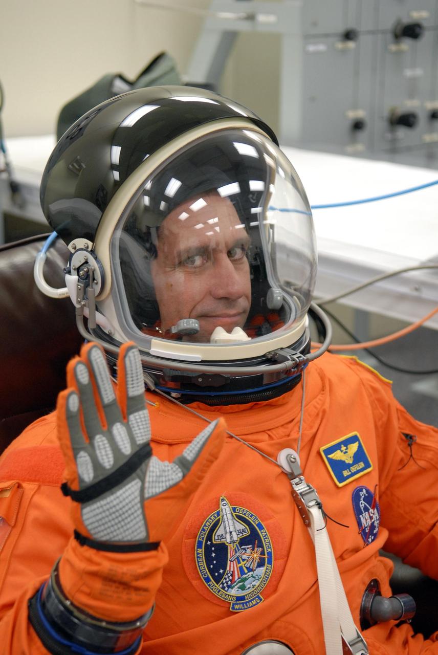 KENNEDY SPACE CENTER, FLA. -- The crew members of mission STS-116 are suiting up for launch at 9:35 p.m. EST from Launch Pad 39B aboard Space Shuttle Discovery.  Pictured here is Pilot William Oefelein, who signals his helmet is working.  Oefelein is making his first shuttle flight. This is Discovery's 33rd mission and the first night launch since 2003.   The 20th shuttle mission to the International Space Station, STS-116 carries another truss segment, P5. It will serve as a spacer, mated to the P4 truss that was attached in September.  After installing the P5, the crew will reconfigure and redistribute the power generated by two pairs of U.S. solar arrays. Landing is expected Dec. 19 at KSC.   Photo credit: NASA/Kim Shiflett