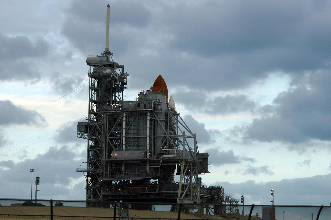 KENNEDY SPACE CENTER, FLA. --   The launch attempt of STS-116 was postponed due a low cloud ceiling over Kennedy Space Center. The next launch attempt was scheduled for Saturday, Dec. 9, at 8:47 p.m.  In the photo, the rotating service structure has been rolled into place around the shuttle.  This will be Discovery's 33rd mission and the first night launch since 2002.   The 20th shuttle mission to the International Space Station, STS-116 carries another truss segment, P5. It will serve as a spacer, mated to the P4 truss that was attached in September.  After installing the P5, the crew will reconfigure and redistribute the power generated by two pairs of U.S. solar arrays. Landing is expected Dec. 19 at KSC.   Photo credit: NASA/Ken Thornsley