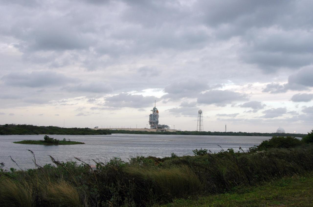 KENNEDY SPACE CENTER, FLA. --   The launch attempt of STS-116 was postponed due a low cloud ceiling over Kennedy Space Center. The next launch attempt was scheduled for Saturday, Dec. 9, at 8:47 p.m.  In the photo, the rotating service structure has been rolled into place around the shuttle.  This will be Discovery's 33rd mission and the first night launch since 2002.   The 20th shuttle mission to the International Space Station, STS-116 carries another truss segment, P5. It will serve as a spacer, mated to the P4 truss that was attached in September.  After installing the P5, the crew will reconfigure and redistribute the power generated by two pairs of U.S. solar arrays. Landing is expected Dec. 19 at KSC.   Photo credit: NASA/Ken Thornsley