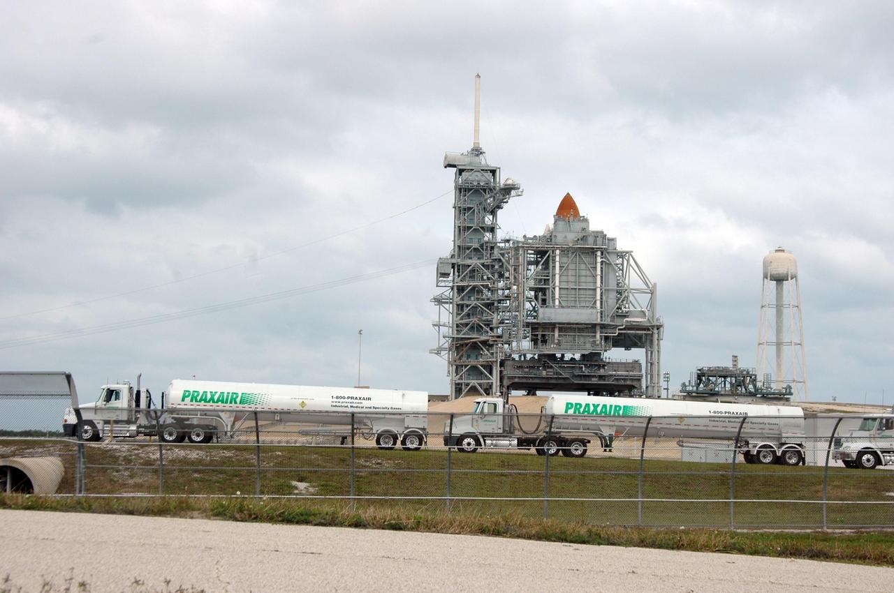 KENNEDY SPACE CENTER, FLA. --     Fuel trucks head for Launch Pad 39B to refill the external tank on Space Shuttle Discovery.  The top of the external tank can be seen above the rotating service structure that encloses the space shuttle.  The launch attempt of Discovery on mission STS-116 was postponed Dec. 7 due a low cloud ceiling over Kennedy Space Center. The next launch attempt was scheduled for Saturday, Dec. 9, at 8:47 p.m. This will be Discovery's 33rd mission and the first night launch since 2002.   The 20th shuttle mission to the International Space Station, STS-116 carries another truss segment, P5. It will serve as a spacer, mated to the P4 truss that was attached in September.  After installing the P5, the crew will reconfigure and redistribute the power generated by two pairs of U.S. solar arrays. Landing is expected Dec. 19 at KSC.   Photo credit: NASA/Ken Thornsley