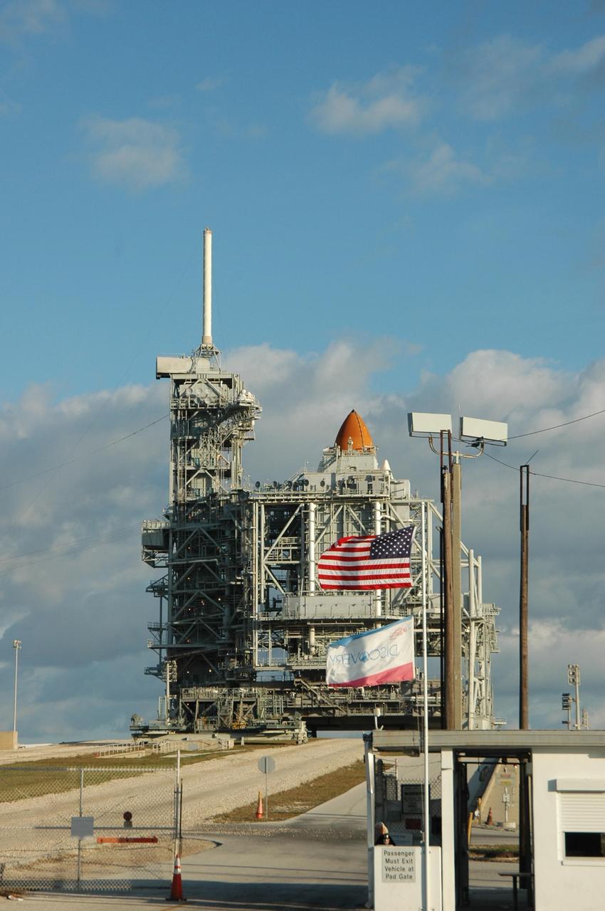 KENNEDY SPACE CENTER, FLA. --   On the morning of the second launch attempt, Space Shuttle Discovery is ready on Launch Pad 39B.  It is still surrounded by the rotating service structure, hiding all but the top of the external tank.  On the left side is the fixed service structure, topped by the 80-foot-tall lightning mast. The first launch attempt of STS-116 Dec. 7 was postponed due a low cloud ceiling over Kennedy Space Center. The next launch attempt was scheduled for Saturday, Dec. 9, at 8:47 p.m. This will be Discovery's 33rd mission and the first night launch since 2002.   The 20th shuttle mission to the International Space Station, STS-116 carries another truss segment, P5. It will serve as a spacer, mated to the P4 truss that was attached in September.  After installing the P5, the crew will reconfigure and redistribute the power generated by two pairs of U.S. solar arrays. Landing is expected Dec. 19 at KSC.  Photo credit: NASA/Ken Thornsley