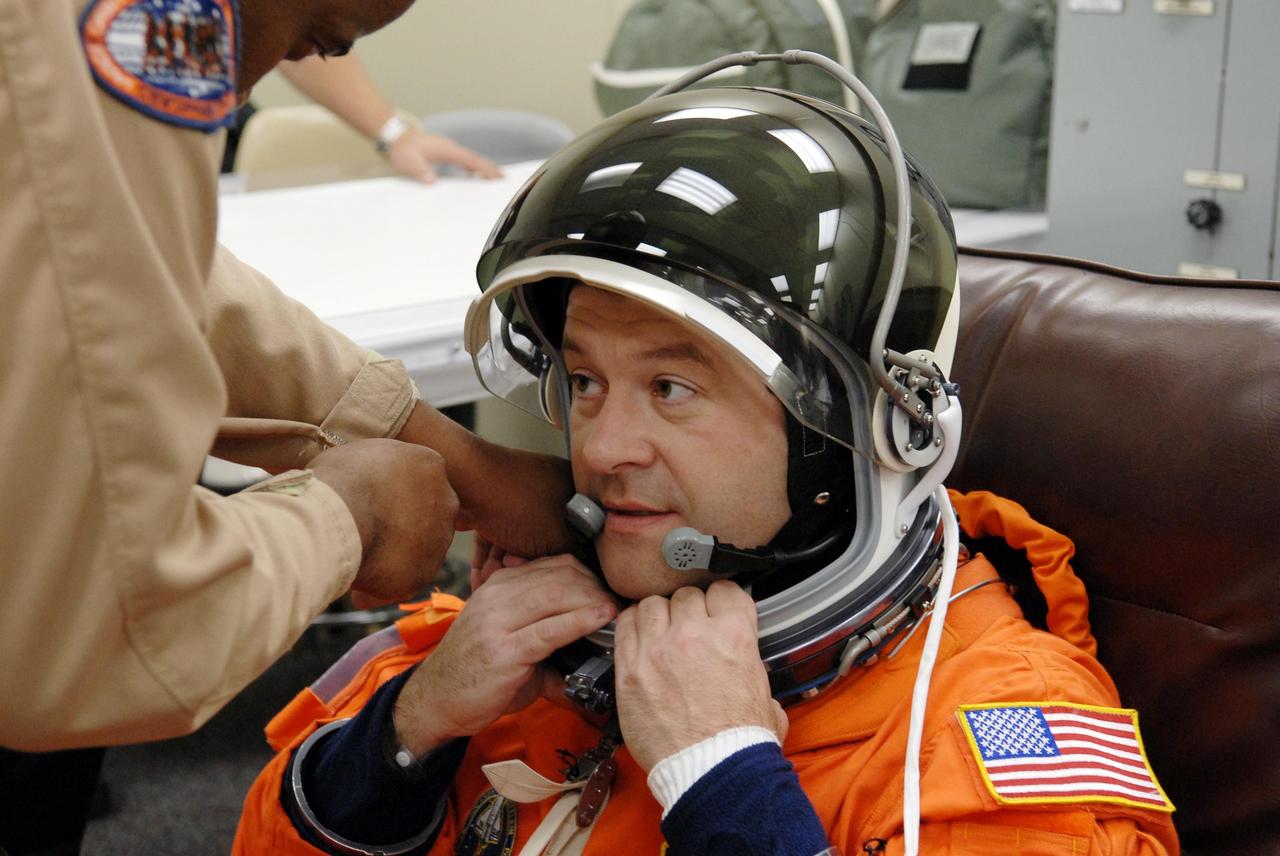 KENNEDY SPACE CENTER, FLA. --   The crew members of mission STS-116 are suiting up for a second launch attempt at 8:47 p.m. EST from Launch Pad 39B aboard Space Shuttle Discovery.  Pictured here is Mission Specialist Nicholas Patrick, who will be making his first shuttle flight, being helped with his helmet. The first launch attempt of STS-116 on Dec. 7 was postponed due a low cloud ceiling over Kennedy Space Center. This is Discovery's 33rd mission and the first night launch since 2002.   The 20th shuttle mission to the International Space Station, STS-116 carries another truss segment, P5. It will serve as a spacer, mated to the P4 truss that was attached in September.  After installing the P5, the crew will reconfigure and redistribute the power generated by two pairs of U.S. solar arrays. Landing is expected Dec. 19 at KSC.   Photo credit: NASA/Kim Shiflett