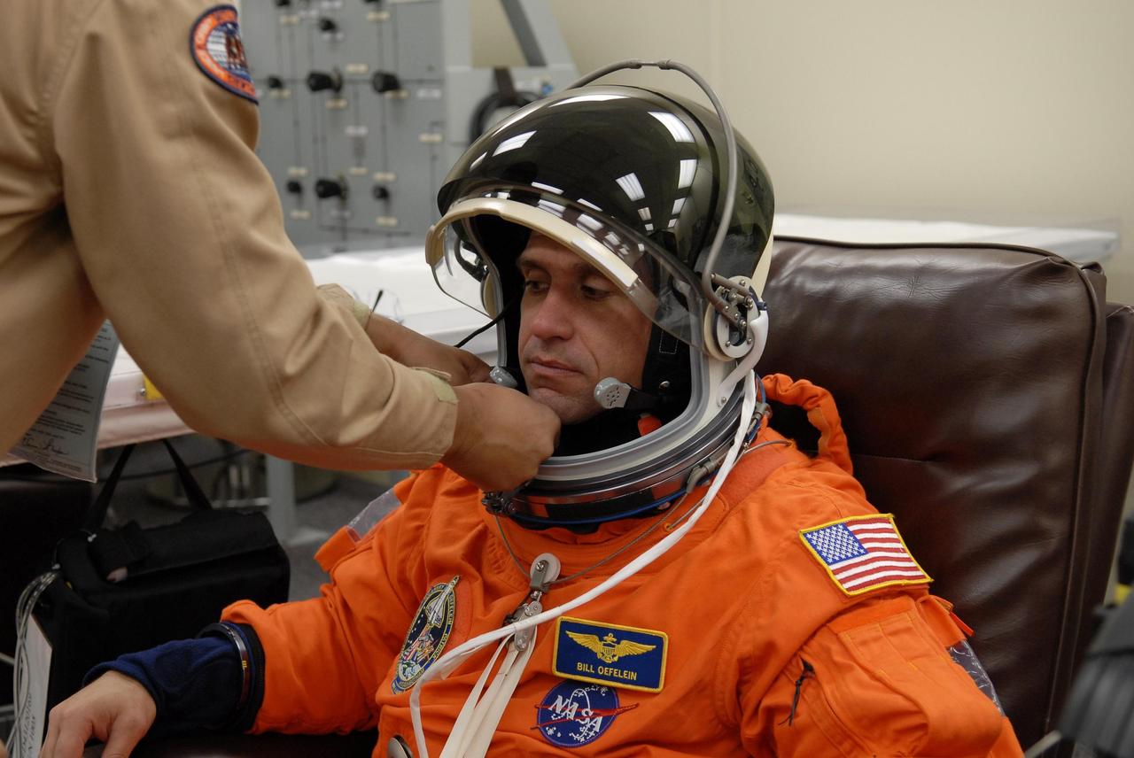 KENNEDY SPACE CENTER, FLA. --   The crew members of mission STS-116 are suiting up for a second launch attempt at 8:47 p.m. EST from Launch Pad 39B aboard Space Shuttle Discovery.  Pictured here is Pilot William Oefelein, being helped with his helmet.  Oefelein is making his first shuttle flight. The first launch attempt of STS-116 on Dec. 7 was postponed due a low cloud ceiling over Kennedy Space Center. This is Discovery's 33rd mission and the first night launch since 2002.   The 20th shuttle mission to the International Space Station, STS-116 carries another truss segment, P5. It will serve as a spacer, mated to the P4 truss that was attached in September.  After installing the P5, the crew will reconfigure and redistribute the power generated by two pairs of U.S. solar arrays. Landing is expected Dec. 19 at KSC.   Photo credit: NASA/Kim Shiflett
