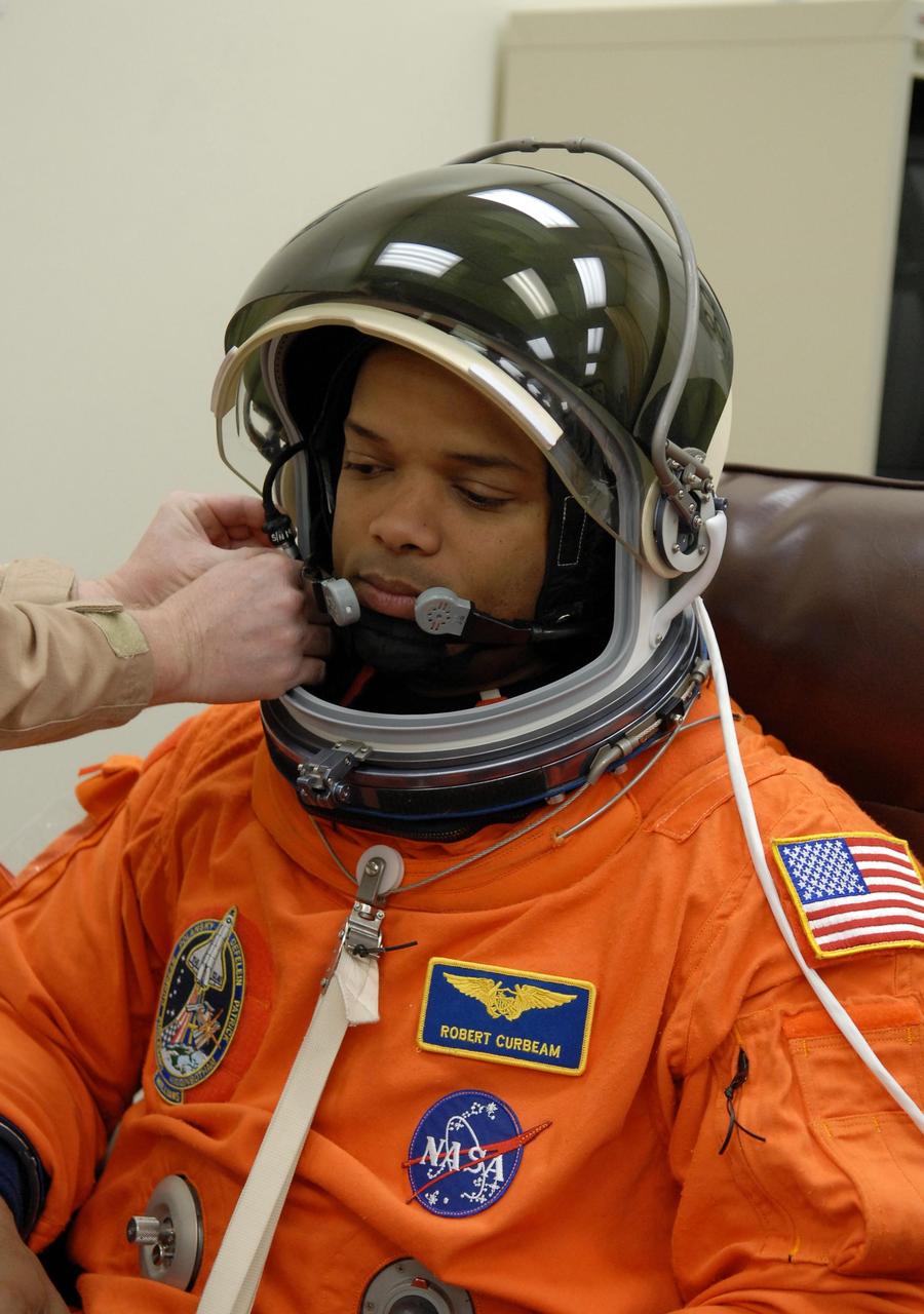 KENNEDY SPACE CENTER, FLA. --   The crew members of mission STS-116 are suiting up for a second launch attempt at 8:47 p.m. EST from Launch Pad 39B aboard Space Shuttle Discovery.  Pictured here is Mission Specialist Robert Curbeam, getting help with the helmet.  Curbeam will be making his third shuttle flight.  The first launch attempt of STS-116 on Dec. 7 was postponed due a low cloud ceiling over Kennedy Space Center. This is Discovery's 33rd mission and the first night launch since 2002.   The 20th shuttle mission to the International Space Station, STS-116 carries another truss segment, P5. It will serve as a spacer, mated to the P4 truss that was attached in September.  After installing the P5, the crew will reconfigure and redistribute the power generated by two pairs of U.S. solar arrays. Landing is expected Dec. 19 at KSC.   Photo credit: NASA/Kim Shiflett