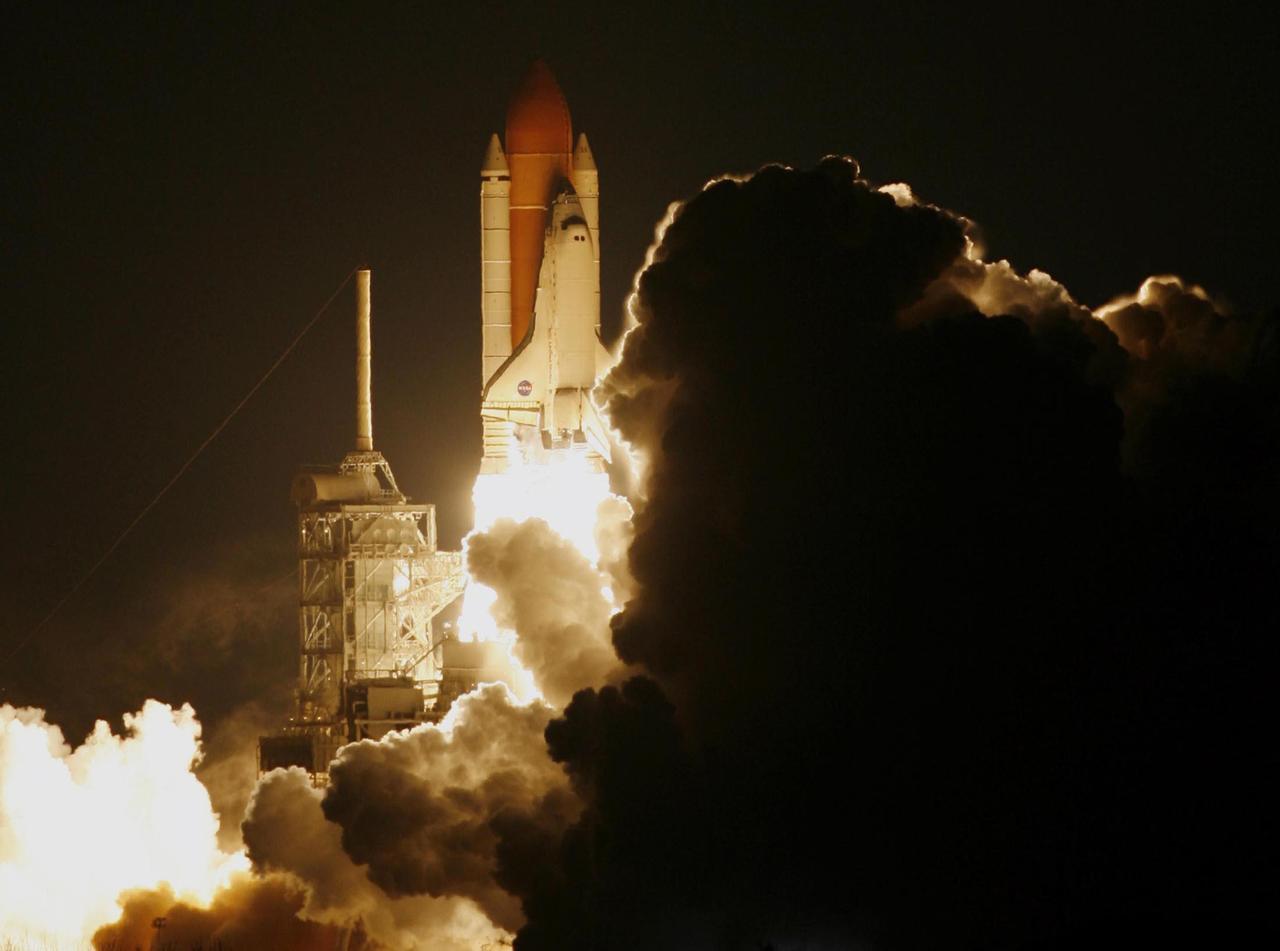 KENNEDY SPACE CENTER, FLA. --  From amid the smoke and steam, Space Shuttle Discovery leaps toward the sky past the lightning mast on Launch Pad 39B on mission STS-116.  The launch occurred at 8:47:35 p.m. EST.  This was the second launch attempt for mission STS-116.  The first launch attempt on Dec. 7 was postponed due a low cloud ceiling over Kennedy Space Center. This is Discovery's 33rd mission and the first night launch since 2002.   The 20th shuttle mission to the International Space Station, STS-116 carries another truss segment, P5. It will serve as a spacer, mated to the P4 truss that was attached in September.  After installing the P5, the crew will reconfigure and redistribute the power generated by two pairs of U.S. solar arrays. Landing is expected Dec. 21 at KSC.   Photo courtesy of Reuters/Larry Rubenstein and Peter Jones