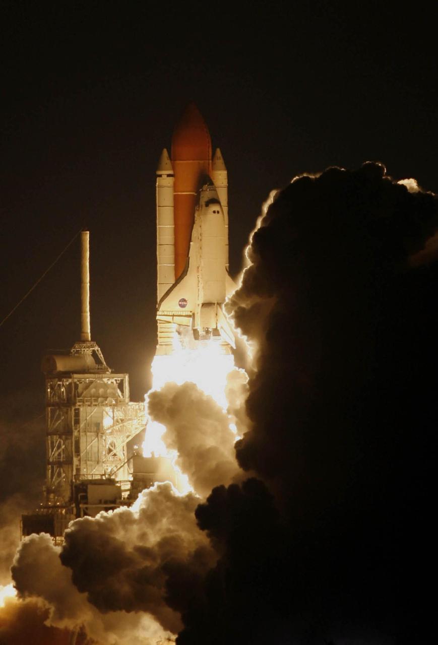 KENNEDY SPACE CENTER, FLA. --  From amid the smoke and steam, Space Shuttle Discovery leaps toward the sky past the lightning mast on Launch Pad 39B on mission STS-116. The launch occurred at 8:47:35 p.m. EST.  This was the second launch attempt for mission STS-116.  The first launch attempt on Dec. 7 was postponed due a low cloud ceiling over Kennedy Space Center. This is Discovery's 33rd mission and the first night launch since 2002.   The 20th shuttle mission to the International Space Station, STS-116 carries another truss segment, P5. It will serve as a spacer, mated to the P4 truss that was attached in September.  After installing the P5, the crew will reconfigure and redistribute the power generated by two pairs of U.S. solar arrays. Landing is expected Dec. 21 at KSC.   Photo courtesy of Reuters/Larry Rubenstein and Peter Jones