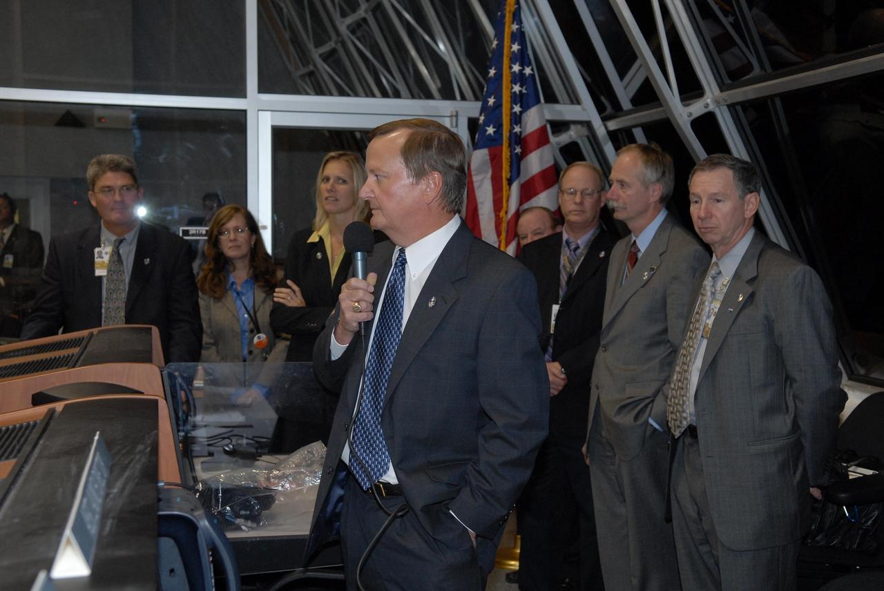KENNEDY SPACE CENTER, FLA. --  In the firing room at the Launch Control Center, Shuttle Launch Director Mike Leinbach (center, with microphone) commends the mission management team for the successful second launch attempt of Space Shuttle Discovery on mission STS-116.  Liftoff occurred on time at 8:47 p.m. EST.  Others in the room are (left to right), Deputy Director Bill Parsons, External Relations Director Lisa Malone, NASA Flow Director for Discovery Stephanie Stilson, NASA KSC News Chief Bruce Buckingham, Associate Administrator for Space Operations Mission William Gerstenmaier and NASA  Administrator Mike Griffin. This was the second launch attempt for mission STS-116.  The first launch attempt on Dec. 7 was postponed due a low cloud ceiling over Kennedy Space Center. This is Discovery's 33rd mission and the first night launch since 2002.   The 20th shuttle mission to the International Space Station, STS-116 carries another truss segment, P5. It will serve as a spacer, mated to the P4 truss that was attached in September.  After installing the P5, the crew will reconfigure and redistribute the power generated by two pairs of U.S. solar arrays. Landing is expected Dec. 21 at KSC.   Photo credit: NASA/Kim Shiflett