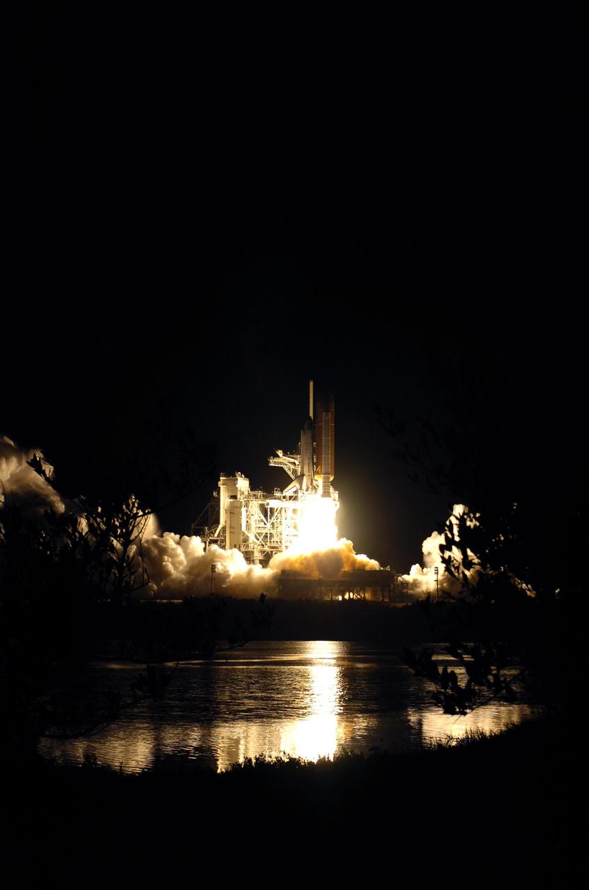 KENNEDY SPACE CENTER, FLA. -- The fiery liftoff of Space Shuttle Discovery from Launch Pad 39B on mission STS-116 is captured in the nearby water. Liftoff occurred on time at 8:47 p.m. EST. This was the second launch attempt of Discovery on mission STS-116.  The first launch attempt on Dec. 7 was postponed due a low cloud ceiling over Kennedy Space Center. This is Discovery's 33rd mission and the first night launch since 2002.   The 20th shuttle mission to the International Space Station, STS-116 carries another truss segment, P5. It will serve as a spacer, mated to the P4 truss that was attached in September.  After installing the P5, the crew will reconfigure and redistribute the power generated by two pairs of U.S. solar arrays. Landing is expected Dec. 21 at KSC.   Photo credit: NASA/Sandra Joseph, Robert Murray, Chris Lynch