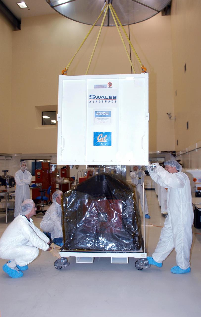 KENNEDY SPACE CENTER, FLA. -- At Astrotech Space Operations in Titusville, Fla., technicians help lower a shipping container over one of the five THEMIS probes for its move to the hazardous processing facility. There it will be placed on a stand in preparation for fueling operations. Once fueling is complete, each probe will be weighed and individually mated to the payload carrier before pyrotechnics are installed. The fully integrated THEMIS payload is then ready for spin-balance testing and weighing. The final milestone is mating THEMIS to its upper stage booster. THEMIS consists of five identical probes, the largest number of scientific satellites ever launched into orbit aboard a single rocket. This unique constellation of satellites will resolve the tantalizing mystery of what causes the spectacular sudden brightening of the aurora borealis and aurora australis - the fiery skies over the Earth's northern and southern polar regions. These lights are the visible manifestations of invisible energy releases, called geomagnetic substorms, in near-Earth space. THEMIS will not only seek to answer where and when substorms start, but will also provide clues as to how and why these space storms create havoc on satellites, terrestrial power grids, and communication systems. THEMIS will be transported to Pad 17-B at Cape Canaveral Air Force Station on February 1 for mating to the Delta II rocket. Launch is scheduled for Feb. 15. Photo credit: NASA/George Shelton