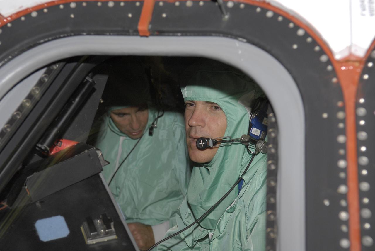 KENNEDY SPACE CENTER, FLA. -- In the Orbiter Processing Facility, STS-117 Commander Frederick (Rick) Sturckow (right) and Pilot Lee Archambault look over the cockpit of the orbiter Atlantis, their vehicle for the mission. They and other crew members are at KSC to take part in a Crew Equipment Interface Test that allows them opportunities to become familiar with equipment and hardware for their mission. STS-117 will deliver the S3/S4 and another pair of solar arrays to the space station.  The 21st shuttle mission to the International Space Station, STS-117 is scheduled to launch no earlier than March 16.  Photo credit: NASA/Kim Shiflett