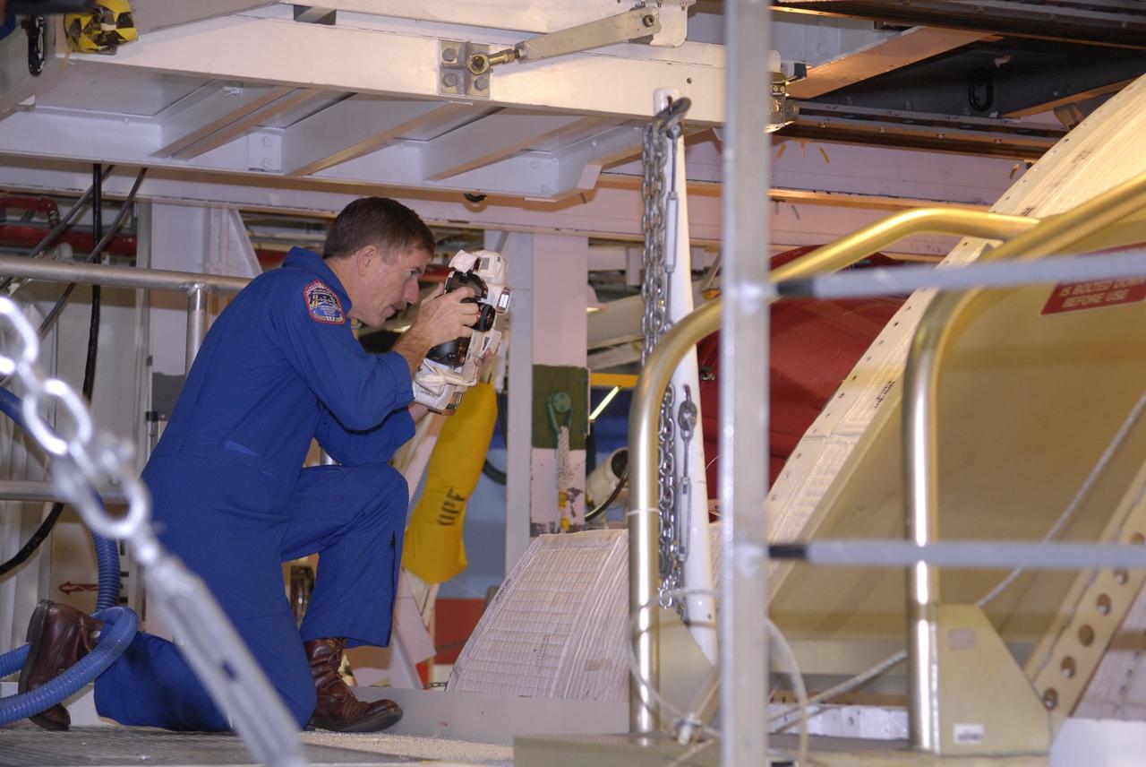 KENNEDY SPACE CENTER, FLA. --  In the Orbiter Processing Facility, STS-117 Mission Specialist James Reilly practices photographing the orbiter Atlantis with a camera to be used on the mission.   He and other crew members are at KSC to take part in a Crew Equipment Interface Test that allows them opportunities to become familiar with equipment and hardware for their mission. STS-117 will deliver the S3/S4 and another pair of solar arrays to the space station.  The 21st shuttle mission to the International Space Station, STS-117 is scheduled to launch no earlier than March 16.  Photo credit: NASA/Kim Shiflett