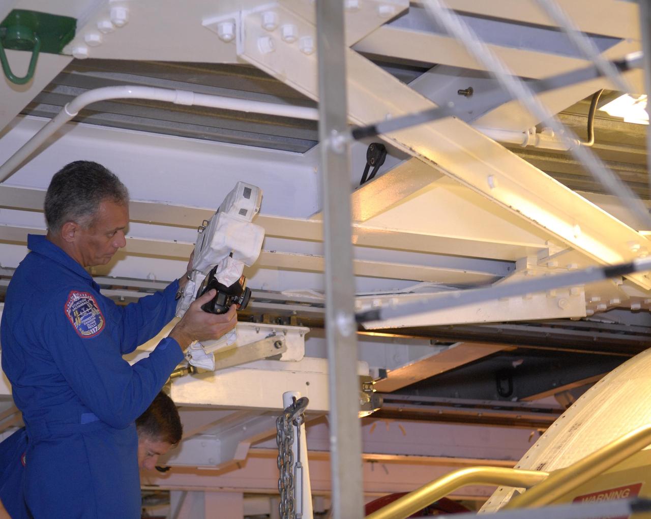 KENNEDY SPACE CENTER, FLA. --  In the Orbiter Processing Facility, STS-117 Mission Specialist John (Danny) Olivas practices photographing the orbiter Atlantis with a camera to be used on the mission.  He and other crew members are at KSC to take part in a Crew Equipment Interface Test that allows them opportunities to become familiar with equipment and hardware for their mission. STS-117 will deliver the S3/S4 and another pair of solar arrays to the space station.  The 21st shuttle mission to the International Space Station, STS-117 is scheduled to launch no earlier than March 16.  Photo credit: NASA/Kim Shiflett