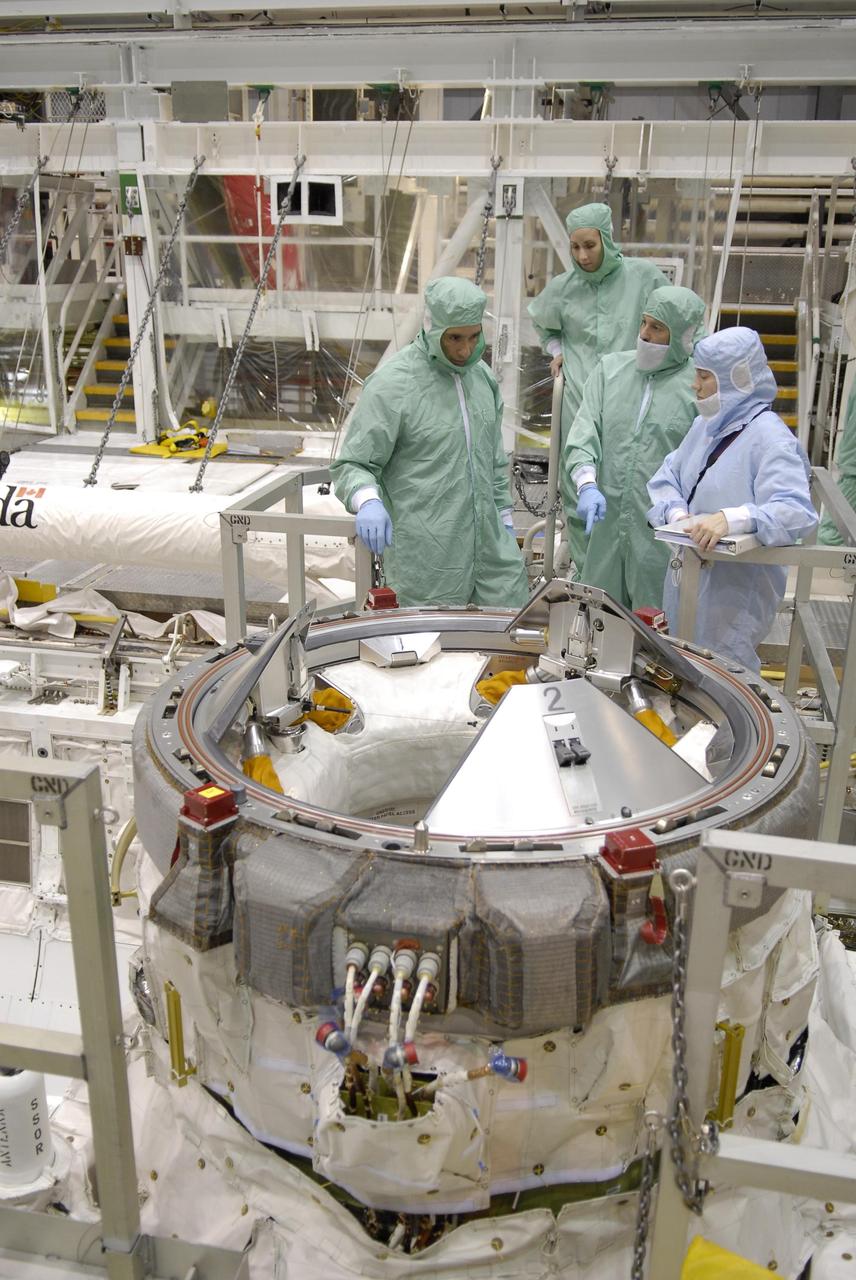 KENNEDY SPACE CENTER, FLA. -- In the Orbiter Processing Facility, STS-117 Pilot Lee Archambault (left) and Mission Specialist James Reilly (second from right) look at a part of the external airlock in the payload bay of Atlantis.  They and other crew members are at KSC to take part in a Crew Equipment Interface Test that allows them opportunities to become familiar with equipment and hardware for their mission. STS-117 will deliver the S3/S4 and another pair of solar arrays to the space station.  The 21st shuttle mission to the International Space Station, STS-117 is scheduled to launch no earlier than March 16.  Photo credit: NASA/Kim Shiflett