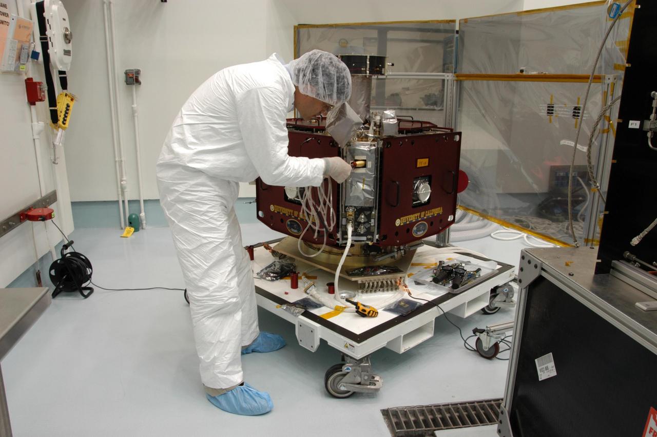 KENNEDY SPACE CENTER, FLA. -- At Astrotech Space Operations in Titusville, Fla., a worker prepares one of the THEMIS probes for electrical system checkout. THEMIS consists of five identical probes, the largest number of scientific satellites ever launched into orbit aboard a single rocket. This unique constellation of satellites will resolve the tantalizing mystery of what causes the spectacular sudden brightening of the aurora borealis and aurora australis - the fiery skies over the Earth's northern and southern polar regions. THEMIS is scheduled to launch Feb. 15 from Cape Canaveral Air Force Station. Photo credit: NASA/George Shelton