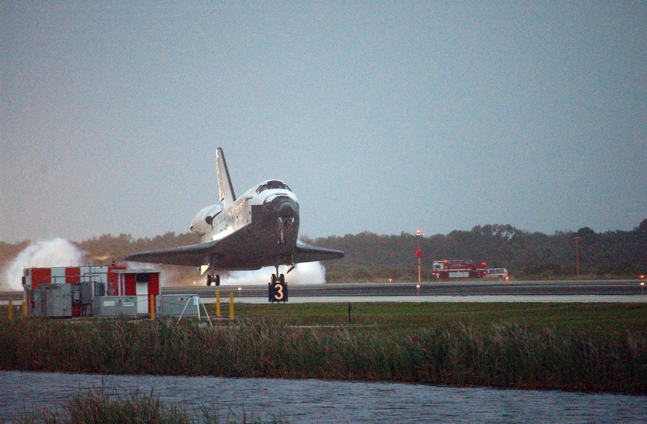 KENNEDY SPACE CENTER, FLA. -- On the shortest day of the year, Discovery touches down at sunset on Runway 15 at NASA Kennedy Space Center's Shuttle Landing Facility as the sun sets, concluding mission STS-116. The rescue vehicles in the background are in position in the unlikely event they are needed during post-landing operations. Aboard are Commander Mark Polansky, Pilot William Oefelein, and Mission Specialists Robert Curbeam, Joan Higginbotham, Nicholas Patrick and Christer Fuglesang, who represents the European Space Agency, as well as Thomas Reiter, who is returning from a 6-month stay on the International Space Station. During the mission, three spacewalks attached the P5 integrated truss structure to the station, and completed the rewiring of the orbiting laboratory's power system. A fourth spacewalk retracted a stubborn solar array. Main gear touchdown was at 5:32 p.m. EST. Nose gear touchdown was at 5:32:12 p.m. and wheel stop was at 5:32:52 p.m. At touchdown -- nominally about 2,500 ft. beyond the runway threshold -- the orbiter is traveling at a speed ranging from 213 to 226 mph. Discovery traveled 5,330,000 miles, landing on orbit 204. Mission elapsed time was 12 days, 20 hours, 44 minutes and 16 seconds. This is the 64th landing at KSC. Photo credit: NASA/Mike Kerley