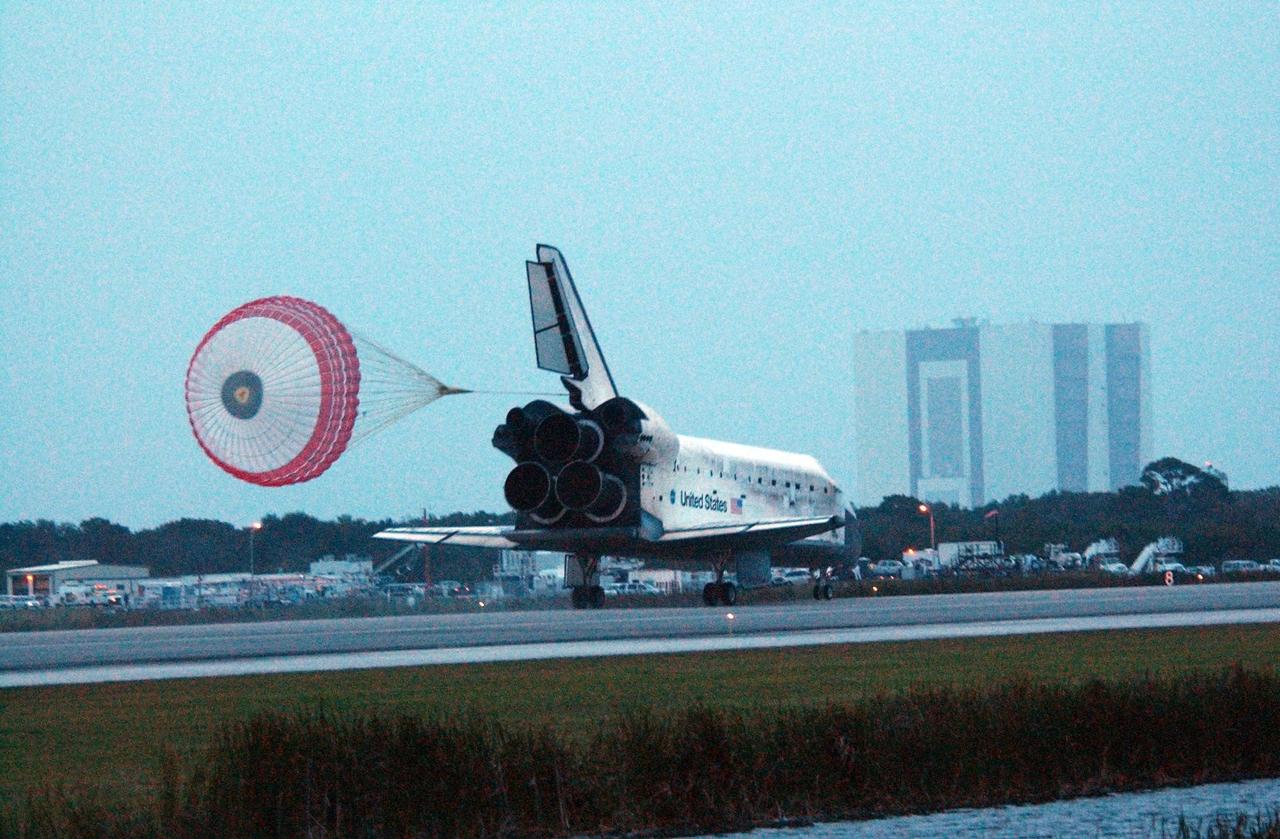 KENNEDY SPACE CENTER, FLA. -- Space Shuttle Discovery's drag chute unfurls upon landing on Runway 15 at NASA Kennedy Space Center's Shuttle Landing Facility as the sun sets on the shortest day of the year, concluding mission STS-116. In the background is the 525-foot-tall Vehicle Assembly Building. Aboard are Commander Mark Polansky, Pilot William Oefelein, and Mission Specialists Robert Curbeam, Joan Higginbotham, Nicholas Patrick and Christer Fuglesang, who represents the European Space Agency, as well as Thomas Reiter, who is returning from a 6-month stay on the International Space Station. During the mission, three spacewalks attached the P5 integrated truss structure to the station, and completed the rewiring of the orbiting laboratory's power system. A fourth spacewalk retracted a stubborn solar array. Main gear touchdown was at 5:32 p.m. EST. Nose gear touchdown was at 5:32:12 p.m. and wheel stop was at 5:32:52 p.m. At touchdown -- nominally about 2,500 ft. beyond the runway threshold -- the orbiter is traveling at a speed ranging from 213 to 226 mph. Discovery traveled 5,330,000 miles, landing on orbit 204. Mission elapsed time was 12 days, 20 hours, 44 minutes and 16 seconds. This is the 64th landing at KSC. Photo credit: NASA/Tom Joseph