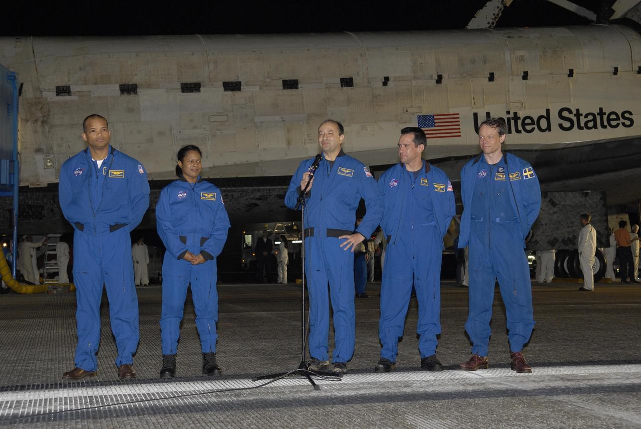 KENNEDY SPACE CENTER, FLA. -- STS-116 Commander Mark Polansky says a few words for the NASA Television viewing audience following the landing of Discovery on Runway 15 at NASA Kennedy Space Center's Shuttle Landing Facility. From left are Mission Specialists Robert Curbeam and Joan Higginbotham, Polansky, Pilot William Oefelein and Mission Specialist Christer Fuglesang, who represents the European Space Agency. Other astronauts aboard Discovery not shown are Mission Specialist Nicholas Patrick and European Space Agency astronaut Thomas Reiter, who is returning from a 6-month stay on the International Space Station. During the mission, three spacewalks attached the P5 integrated truss structure to the station, and completed the rewiring of the orbiting laboratory's power system. A fourth spacewalk retracted a stubborn solar array. Main gear touchdown was at 5:32 p.m. EST. Nose gear touchdown was at 5:32:12 p.m. and wheel stop was at 5:32:52 p.m. At touchdown -- nominally about 2,500 ft. beyond the runway threshold -- the orbiter is traveling at a speed ranging from 213 to 226 mph. Discovery traveled 5,330,000 miles, landing on orbit 204. Mission elapsed time was 12 days, 20 hours, 44 minutes and 16 seconds. This is the 64th landing at KSC. Photo credit: NASA/Kim Shiflett