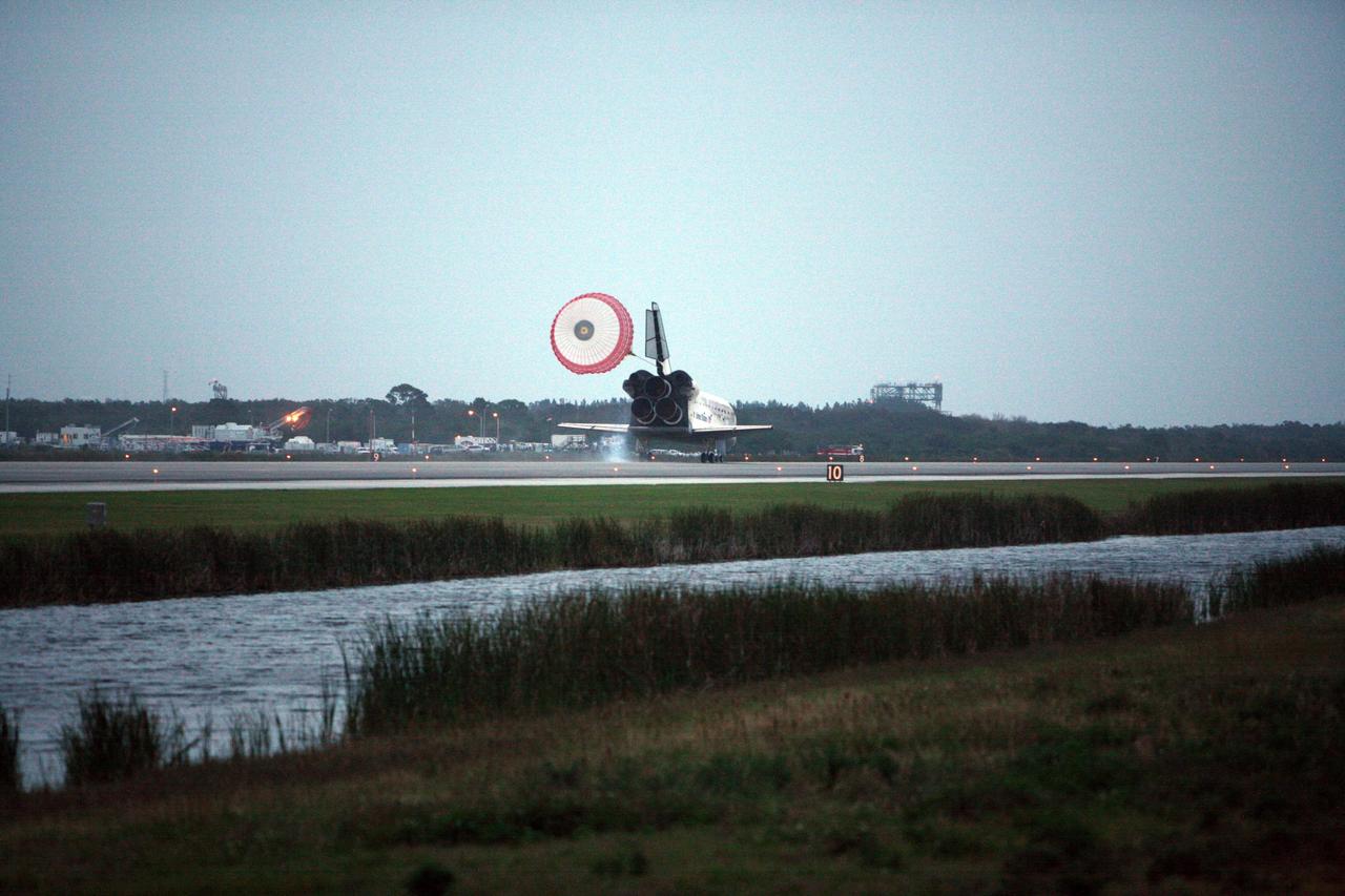 KENNEDY SPACE CENTER, FLA. -- Space Shuttle Discovery's drag chute unfurls upon landing on Runway 15 at NASA Kennedy Space Center's Shuttle Landing Facility as the sun sets on the shortest day of the year, concluding mission STS-116. In the background, right of the space shuttle, is the landing strip's Mate-Demate Device. Aboard Discovery are Commander Mark Polansky, Pilot William Oefelein, and Mission Specialists Robert Curbeam, Joan Higginbotham, Nicholas Patrick and Christer Fuglesang, who represents the European Space Agency, as well as Thomas Reiter, who is returning from a 6-month stay on the International Space Station. During the mission, three spacewalks attached the P5 integrated truss structure to the station, and completed the rewiring of the orbiting laboratory’s power system. A fourth spacewalk retracted a stubborn solar array. Main gear touchdown was at 5:32 p.m. EST. Nose gear touchdown was at 5:32:12 p.m. and wheel stop was at 5:32:52 p.m. At touchdown -- nominally about 2,500 ft. beyond the runway threshold -- the orbiter is traveling at a speed ranging from 213 to 226 mph. Discovery traveled 5,330,000 miles, landing on orbit 204. Mission elapsed time was 12 days, 20 hours, 44 minutes and 16 seconds. This is the 64th landing at KSC. Photo credit: NASA/Chris Lynch
