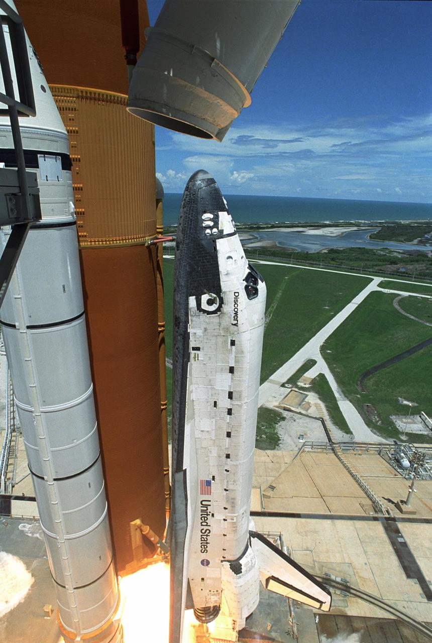 KENNEDY SPACE CENTER, FLA. - Making history with the first-ever launch on Independence Day, Space Shuttle Discovery on mission STS-121 lifts off Launch Pad 39B beneath it with a fiery blaze from the solid rocket boosters. In the background, clouds build over the Atlantic Ocean. During the 12-day mission, the STS-121 crew of seven will test new equipment and procedures to improve shuttle safety, as well as deliver supplies and make repairs to the International Space Station. Landing is scheduled for July 16 or 17 at Kennedy's Shuttle Landing Facility. Photo credit: NASA/Regina Mitchell-Ryall & Don Kight