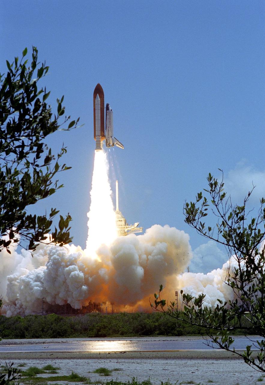 KENNEDY SPACE CENTER, FLA. -    Making history with the first-ever launch on Independence Day, Space Shuttle Discovery clears the lightning mast and rockets into the blue sky on mission STS-121, trailing fiery exhaust. Liftoff was on-time at 2:38 p.m. EDT.  During the 12-day mission, the STS-121 crew of seven will test new equipment and procedures to improve shuttle safety, as well as deliver supplies and make repairs to the International Space Station.  Landing is scheduled for July 16 or 17 at Kennedy's Shuttle Landing Facility.   Photo credit: NASA/Sandy Joseph & Robert Murray