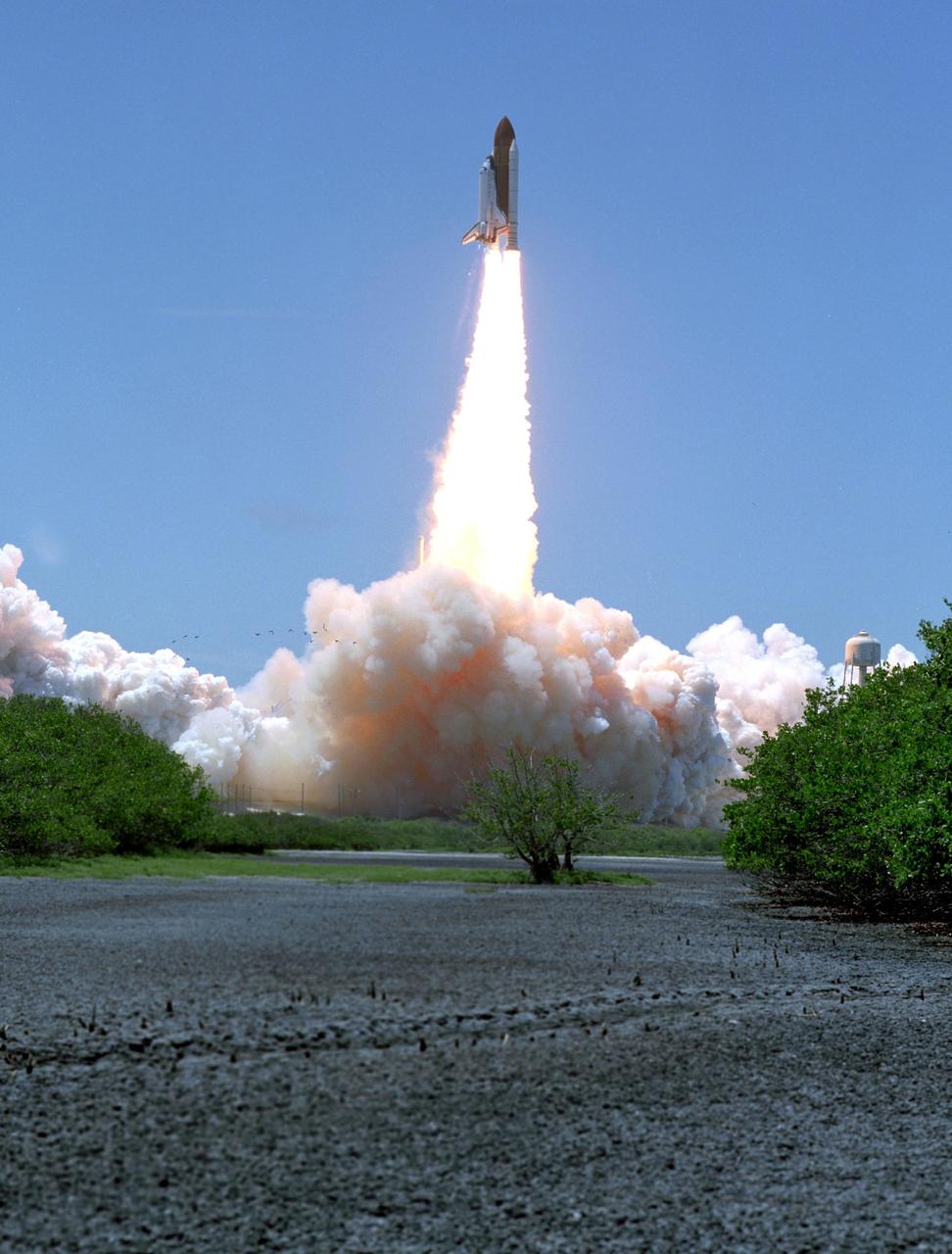 KENNEDY SPACE CENTER, FLA. -   As if erupting from the earth and smoke, Space Shuttle Discovery vaults into the clear blue sky, trailing a fiery plume, on mission STS-121.  The launch was the first ever made on Independence Day.  Liftoff was on-time at 2:38 p.m. EDT.  During the 12-day mission, the STS-121 crew of seven will test new equipment and procedures to improve shuttle safety, as well as deliver supplies and make repairs to the International Space Station.  Landing is scheduled for July 16 or 17 at Kennedy's Shuttle Landing Facility.  Photo credit: NASA/Sandy Joseph & Robert Murray