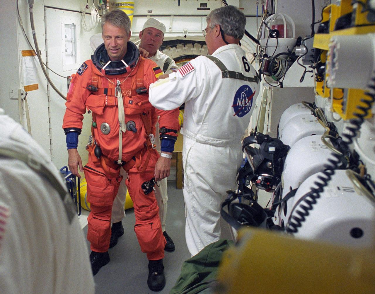 KENNEDY SPACE CENTER, FLA. -    In the White Room on Launch Pad 39B, STS-121 Mission Specialist Thomas Reiter  is helped by the Closeout Crew to prepare for entering Discovery and the launch.  Situated on the end of the orbiter access arm, the White Room provides access into the orbiter on the pad.  The crew is preparing for the third launch attempt in four days; previous attempts were scrubbed due to weather concerns.  During the 12-day mission, the STS-121 crew will test new equipment and procedures to improve shuttle safety, as well as deliver supplies and make repairs to the International Space Station. The launch of Space Shuttle Discovery on mission STS-121 is the 115th shuttle flight and the 18th U.S. flight to the International Space Station.  Photo credit: NASA/Regina Mitchell-Ryall & Tony Gray