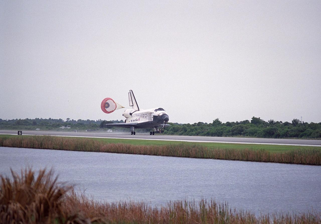 KENNEDY SPACE CENTER, FLA. -    The orbiter Discovery releases a drag chute to slow its speed as it touches down on Runway 15 at NASA's Shuttle Landing Facility after completing mission STS-121 to the International Space Station.   Discovery traveled  5.3 million miles, landing on orbit 202.  Mission elapsed time was 12 days, 18 hours, 37 minutes and 54 seconds.  Main gear touchdown occurred on time at 9:14:43 EDT.  Wheel stop was at 9:15:49 EDT.  The returning crew members aboard are Commander Steven Lindsey, Pilot Mark Kelly and Mission Specialists Piers Sellers, Michael Fossum, Lisa Nowak and Stephanie Wilson.  Mission Specialist Thomas Reiter, who launched with the crew on July 4, remained on the station to join the Expedition 13 crew there.  The landing is the 62nd at Kennedy Space Center and the 32nd for Discovery.  During the mission, the STS-121 crew tested new equipment and procedures to improve shuttle safety, and delivered supplies and made repairs to the International Space Station. Photo credit: NASA/Regina Mitchell-Ryall
