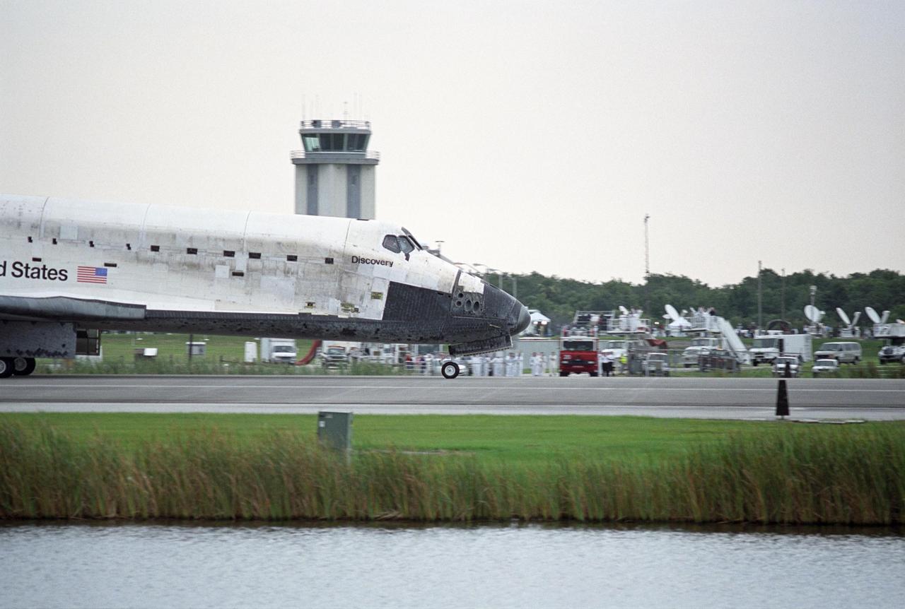 KENNEDY SPACE CENTER, FLA. -   The orbiter Discovery passes dozens of satellite trucks and media at midfield after landing on Runway 15 at NASA's Shuttle Landing Facility, completing mission STS-121 to the International Space Station.  Discovery traveled  5.3 million miles, landing on orbit 202.  Mission elapsed time was 12 days, 18 hours, 37 minutes and 54 seconds.  Main gear touchdown occurred on time at 9:14:43 EDT.  Wheel stop was at 9:15:49 EDT.  The returning crew members aboard are Commander Steven Lindsey, Pilot Mark Kelly and Mission Specialists Piers Sellers, Michael Fossum, Lisa Nowak and Stephanie Wilson.  Mission Specialist Thomas Reiter, who launched with the crew on July 4, remained on the station to join the Expedition 13 crew there.  The landing is the 62nd at Kennedy Space Center and the 32nd for Discovery.  During the mission, the STS-121 crew tested new equipment and procedures to improve shuttle safety, and delivered supplies and made repairs to the International Space Station. Photo credit: NASA/Regina Mitchell-Ryall