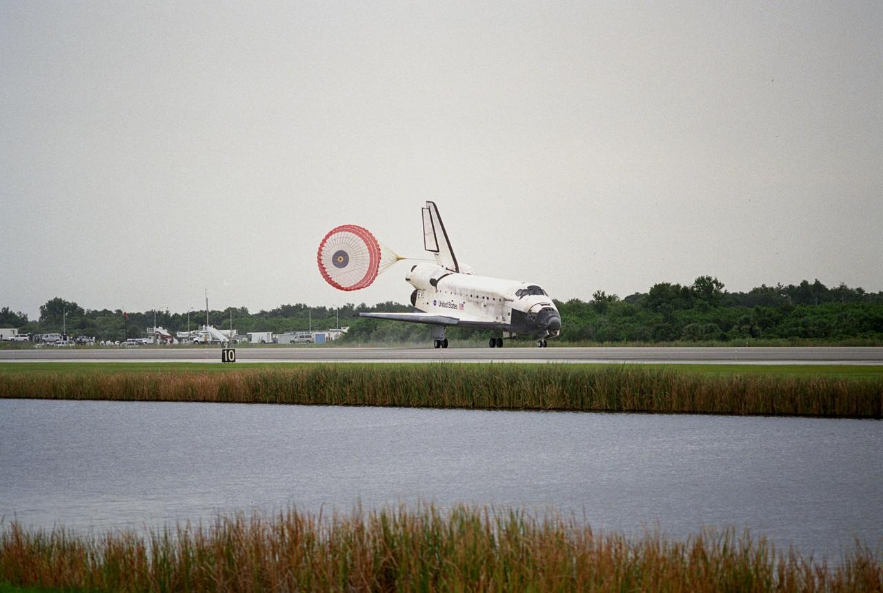 KENNEDY SPACE CENTER, FLA. - The drag chute begins to fall after the orbiter Discovery slows to a stop on Runway 15 at NASA's Shuttle Landing Facility, completing mission STS-121 to the International Space Station. Discovery traveled 5.3 million miles, landing on orbit 202. Mission elapsed time was 12 days, 18 hours, 37 minutes and 54 seconds. Main gear touchdown occurred on time at 9:14:43 EDT. Wheel stop was at 9:15:49 EDT. The returning crew members aboard are Commander Steven Lindsey, Pilot Mark Kelly and Mission Specialists Piers Sellers, Michael Fossum, Lisa Nowak and Stephanie Wilson. Mission Specialist Thomas Reiter, who launched with the crew on July 4, remained on the station to join the Expedition 13 crew there. The landing is the 62nd at Kennedy Space Center and the 32nd for Discovery. During the mission, the STS-121 crew tested new equipment and procedures to improve shuttle safety, and delivered supplies and made repairs to the International Space Station. Photo credit: NASA/Tim Terry