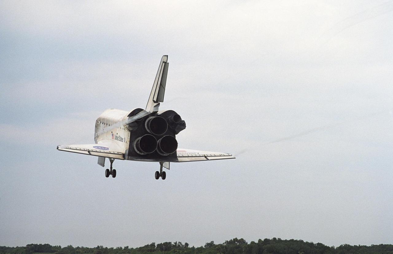 KENNEDY SPACE CENTER, FLA. - Vapor trails flow from Discovery's wing tips as it makes a speedy approach to Runway 15 at NASA's Shuttle Landing Facility, completing mission STS-121 to the International Space Station. At touchdown -- nominally about 2,500 ft. beyond the runway threshold -- the orbiter is traveling at a speed ranging from 213 to 226 mph. Discovery traveled 5.3 million miles, landing on orbit 202. Mission elapsed time was 12 days, 18 hours, 37 minutes and 54 seconds. Main gear touchdown occurred on time at 9:14:43 EDT. Wheel stop was at 9:15:49 EDT. The returning crew members aboard are Commander Steven Lindsey, Pilot Mark Kelly and Mission Specialists Piers Sellers, Michael Fossum, Lisa Nowak and Stephanie Wilson. Mission Specialist Thomas Reiter, who launched with the crew on July 4, remained on the station to join the Expedition 13 crew there. The landing is the 62nd at Kennedy Space Center and the 32nd for Discovery. During the mission, the STS-121 crew tested new equipment and procedures to improve shuttle safety, and delivered supplies and made repairs to the International Space Station. Photo credit: NASA/Tony Gray & Tim Powers
