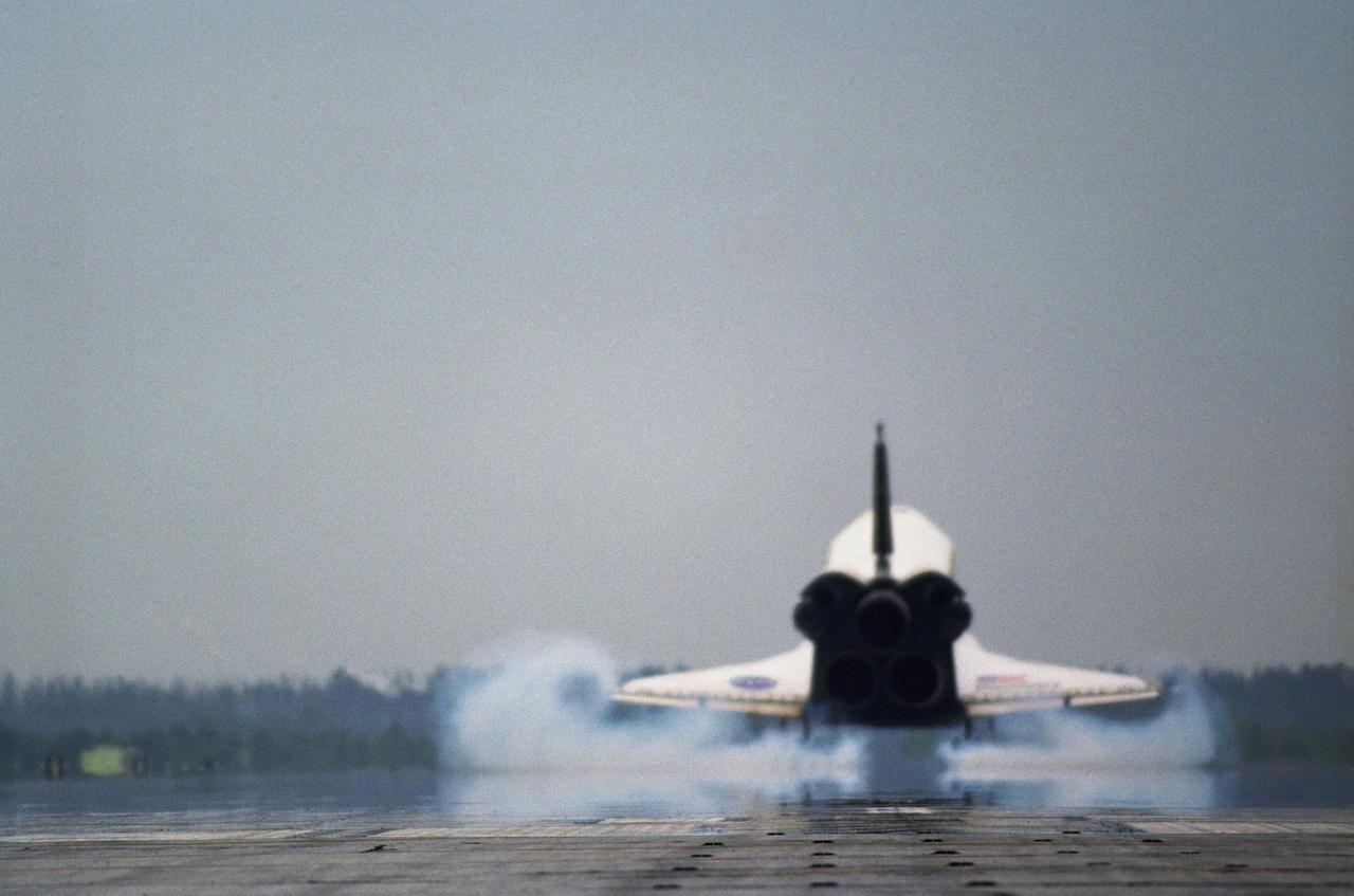 KENNEDY SPACE CENTER, FLA. - Kicking up dust as it touches down on Runway 15 at NASA's Shuttle Landing Facility, the orbiter Discovery completes mission STS-121 to the International Space Station. At touchdown -- nominally about 2,500 ft. beyond the runway threshold -- the orbiter is traveling at a speed ranging from 213 to 226 mph. Discovery traveled 5.3 million miles, landing on orbit 202. Mission elapsed time was 12 days, 18 hours, 37 minutes and 54 seconds. Main gear touchdown occurred on time at 9:14:43 EDT. Wheel stop was at 9:15:49 EDT. The returning crew members aboard are Commander Steven Lindsey, Pilot Mark Kelly and Mission Specialists Piers Sellers, Michael Fossum, Lisa Nowak and Stephanie Wilson. Mission Specialist Thomas Reiter, who launched with the crew on July 4, remained on the station to join the Expedition 13 crew there. The landing is the 62nd at Kennedy Space Center and the 32nd for Discovery. During the mission, the STS-121 crew tested new equipment and procedures to improve shuttle safety, and delivered supplies and made repairs to the International Space Station. Photo credit: NASA/Tony Gray & Tim Powers