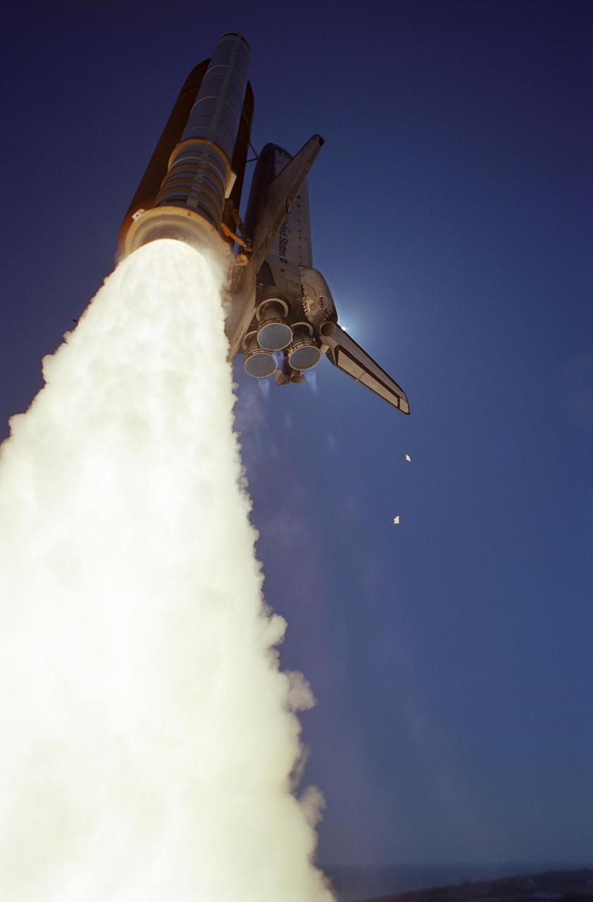 KENNEDY SPACE CENTER, FLA. - Flaming rockets propel Space Shuttle Atlantis into the sky or a rendezvous with the International Space Station on mission STS-115. Appearing below the main engine nozzles s are the blue mach diamonds signal the speed and force at which Atlantis roars into space. Below Atlantis' tail are pieces of ice dislodged during the launch. Liftoff was on-time at 11:14:55 a.m. EDT. After several launch attempts were scrubbed due to weather and technical concerns, this launch was executed perfectly. Mission STS-115 is the 116th space shuttle flight, the 27th flight for orbiter Atlantis, and the 19th U.S. flight to the International Space Station. During the mission, Atlantis' astronauts will deliver and install the 17.5-ton, bus-sized P3/P4 integrated truss segment on the station. The girder-like truss includes a set of giant solar arrays, batteries and associated electronics and will provide one-fourth of the total power-generation capability for the completed station. STS-115 is scheduled to last 11 days with a planned landing at KSC