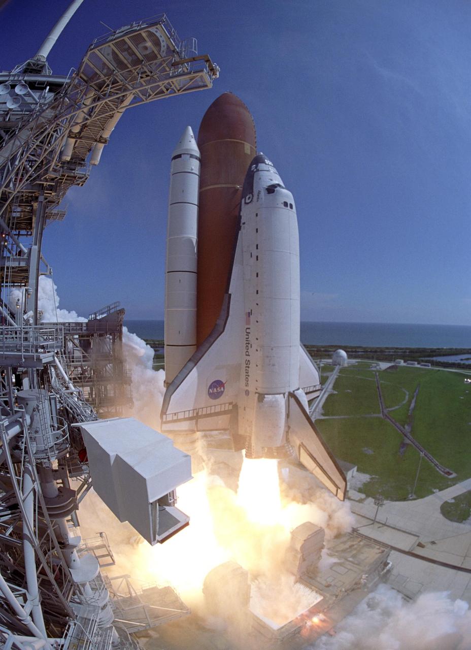 KENNEDY SPACE CENTER, FLA. - A fish-eye view curves the fixed service structure toward Space Shuttle Atlantis as it leaps off Launch Pad 39B, propelled by columns of fire from the solid rocket boosters. At the lower left is the White Room that, when extended against Atlantis, gave the mission crew access to the orbiter. Atlantis is heading for a rendezvous with the International Space Station on mission STS-115. Liftoff was on-time at 11:14:55 a.m. EDT. After several launch attempts were scrubbed due to weather and technical concerns, this launch was executed perfectly. Mission STS-115 is the 116th space shuttle flight, the 27th flight for orbiter Atlantis, and the 19th U.S. flight to the International Space Station. During the mission, Atlantis' astronauts will deliver and install the 17.5-ton, bus-sized P3/P4 integrated truss segment on the station. The girder-like truss includes a set of giant solar arrays, batteries and associated electronics and will provide one-fourth of the total power-generation capability for the completed station. STS-115 is scheduled to last 11 days with a planned landing at KSC