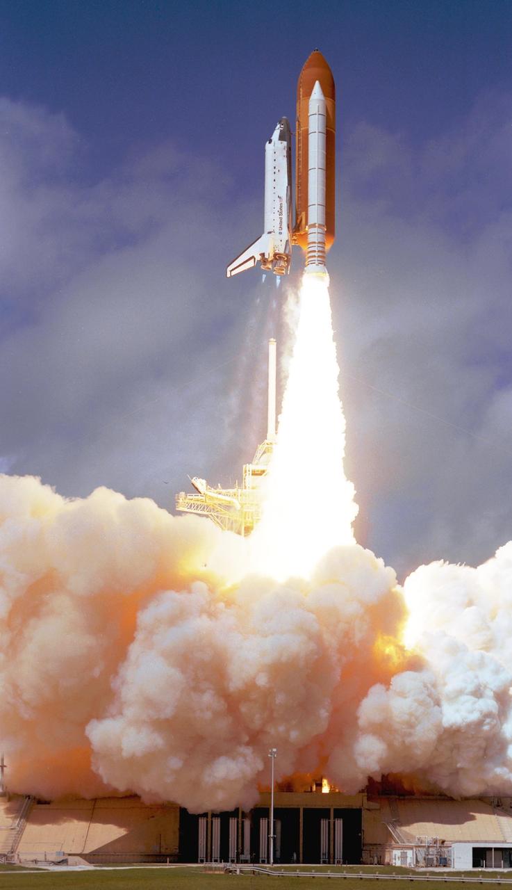 KENNEDY SPACE CENTER, FLA. -  Hurtling toward space, Space Shuttle Atlantis clears the lightning mast atop the fixed service structure on Launch Pad 39B.  Clouds of smoke and steam nearly obscure the pad.  Atlantis is heading for a rendezvous with the International Space Station on mission STS-115.  Liftoff was on-time at 11:14:55 a.m. EDT. After several launch attempts were scrubbed due to weather and technical concerns, this launch was executed perfectly. Mission STS-115 is the 116th space shuttle flight, the 27th flight for orbiter Atlantis, and the 19th U.S. flight to the International Space Station.  During the mission, Atlantis' astronauts will deliver and install the 17.5-ton, bus-sized P3/P4 integrated truss segment on the station. The girder-like truss includes a set of giant solar arrays, batteries and associated electronics and will provide one-fourth of the total power-generation capability for the completed station. STS-115 is scheduled to last 11 days with a planned landing at KSC.