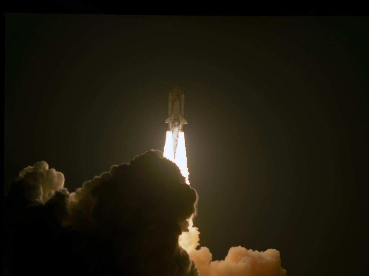 KENNEDY SPACE CENTER, FLA. --   Rising on columns of fire as it emerges from behind the clouds of smoke and steam generated by its liftoff, Space Shuttle Discovery leaps toward the sky past the lightning mast on Launch Pad 39B on mission STS-116.  Liftoff occurred on time at 8:47 p.m. EST. This was the second launch attempt of Discovery on mission STS-116.  The first launch attempt on Dec. 7 was postponed due a low cloud ceiling over Kennedy Space Center. This is Discovery's 33rd mission and the first night launch since 2002.   The 20th shuttle mission to the International Space Station, STS-116 carries another truss segment, P5. It will serve as a spacer, mated to the P4 truss that was attached in September.  After installing the P5, the crew will reconfigure and redistribute the power generated by two pairs of U.S. solar arrays. Landing is expected Dec. 21 at KSC.   Photo credit: NASA/Sandra Joseph, Robert Murray, Chris Lynch