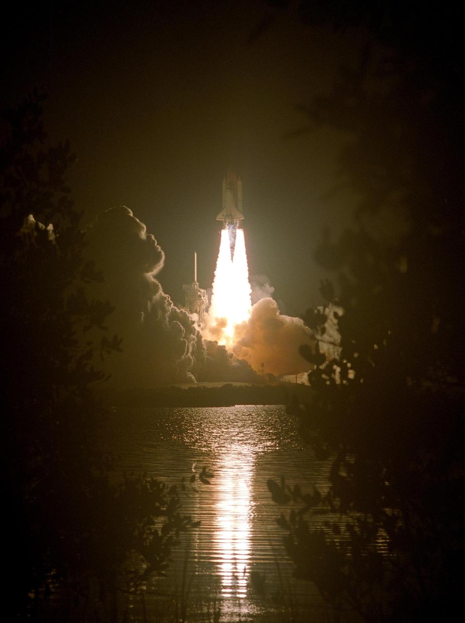 KENNEDY SPACE CENTER, FLA. --    The fiery liftoff of Space Shuttle Discovery from Launch Pad 39B on mission STS-116 is captured in the nearby water. Liftoff occurred on time at 8:47 p.m. EST.  This was the second launch attempt for mission STS-116.  The first launch attempt on Dec. 7 was postponed due a low cloud ceiling over Kennedy Space Center. This is Discovery's 33rd mission and the first night launch since 2002.   The 20th shuttle mission to the International Space Station, STS-116 carries another truss segment, P5. It will serve as a spacer, mated to the P4 truss that was attached in September.  After installing the P5, the crew will reconfigure and redistribute the power generated by two pairs of U.S. solar arrays. Landing is expected Dec. 21 at KSC.   Photo credit: NASA/Sandy Joseph, Robert Murray & Chris Lynch