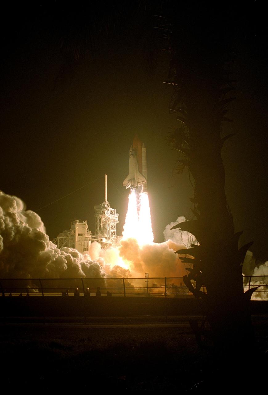 KENNEDY SPACE CENTER, FLA. --   The palm tree at right is silhouetted by the blazing columns propelling Space Shuttle Discovery into the night sky on mission STS-116. Liftoff occurred on time at 8:47 p.m. EST.  This was the second launch attempt for mission STS-116.  The first launch attempt on Dec. 7 was postponed due a low cloud ceiling over Kennedy Space Center. This is Discovery's 33rd mission and the first night launch since 2002.   The 20th shuttle mission to the International Space Station, STS-116 carries another truss segment, P5. It will serve as a spacer, mated to the P4 truss that was attached in September.  After installing the P5, the crew will reconfigure and redistribute the power generated by two pairs of U.S. solar arrays. Landing is expected Dec. 21 at KSC.   Photo credit: NASA/Sandy Joseph, Robert Murray & Chris Lynch