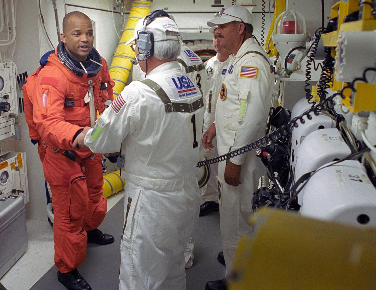 KENNEDY SPACE CENTER, FLA. --    STS-116 Mission Specialist Robert Curbeam thanks the closeout crew for their help in completing his suitup before climbing into Space Shuttle Discovery. The White Room is at the end of the orbiter access arm that extends from the fixed service structure and provides entry into the orbiter.  The first launch attempt of STS-116 on Dec. 7 was postponed due a low cloud ceiling over Kennedy Space Center. This second launch attempt is scheduled for 8:47 p.m. This is Discovery's 33rd mission and the first night launch since 2002.   The 20th shuttle mission to the International Space Station, STS-116 carries another truss segment, P5. It will serve as a spacer, mated to the P4 truss that was attached in September.  After installing the P5, the crew will reconfigure and redistribute the power generated by two pairs of U.S. solar arrays. Landing is expected Dec. 21 at KSC.    Photo credit: NASA/Tony Gray & Don Kight