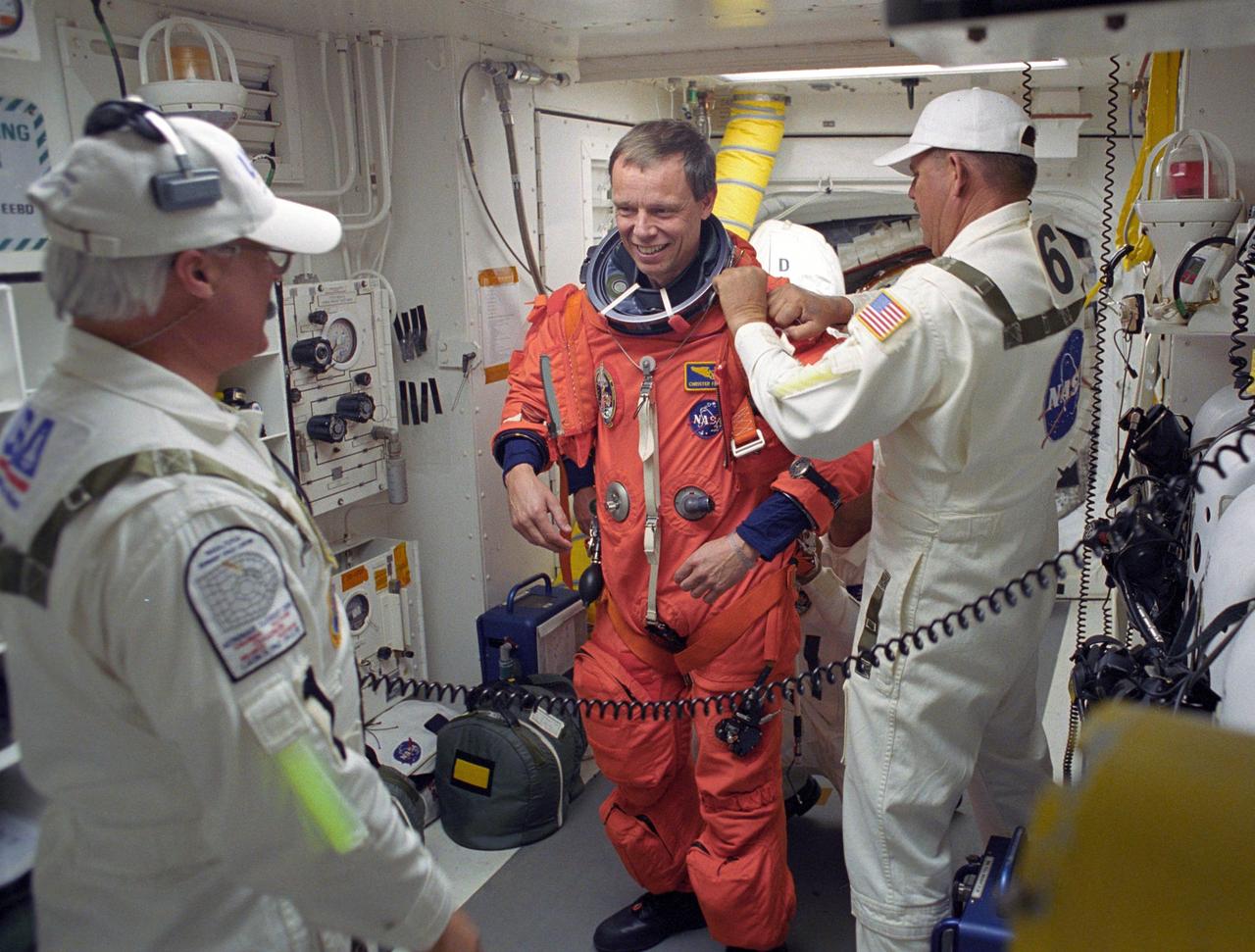 KENNEDY SPACE CENTER, FLA. -- STS-116 Mission Specialist Christer Fuglesang is helped by the closeout crew in the White Room to secure his launch suit before climbing into Space Shuttle Discovery. Fuglesang represents the European Space Agency. The White Room is at the end of the orbiter access arm that extends from the fixed service structure and provides entry into the orbiter. The first launch attempt of STS-116 on Dec. 7 was postponed due a low cloud ceiling over Kennedy Space Center. This second launch attempt is scheduled for 8:47 p.m. This is Discovery's 33rd mission and the first night launch since 2002. The 20th shuttle mission to the International Space Station, STS-116 carries another truss segment, P5. It will serve as a spacer, mated to the P4 truss that was attached in September. After installing the P5, the crew will reconfigure and redistribute the power generated by two pairs of U.S. solar arrays. Landing is expected Dec. 21 at KSC. Photo credit: NASA/Tony Gray & Don Kight